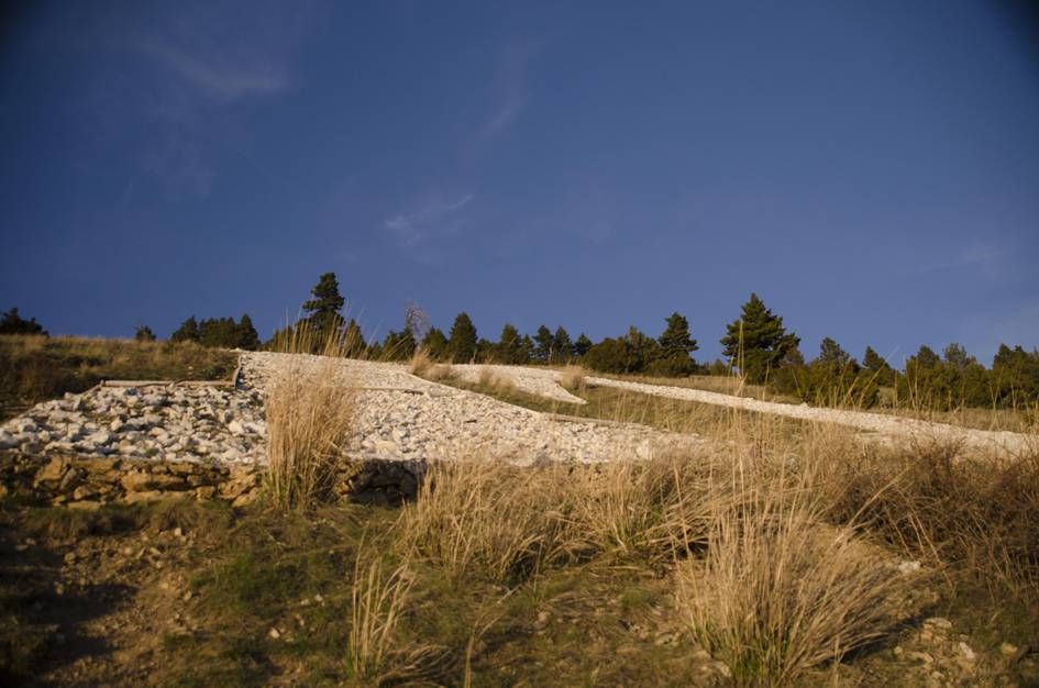 The M formed by white limestone rocks on grassy hillside
