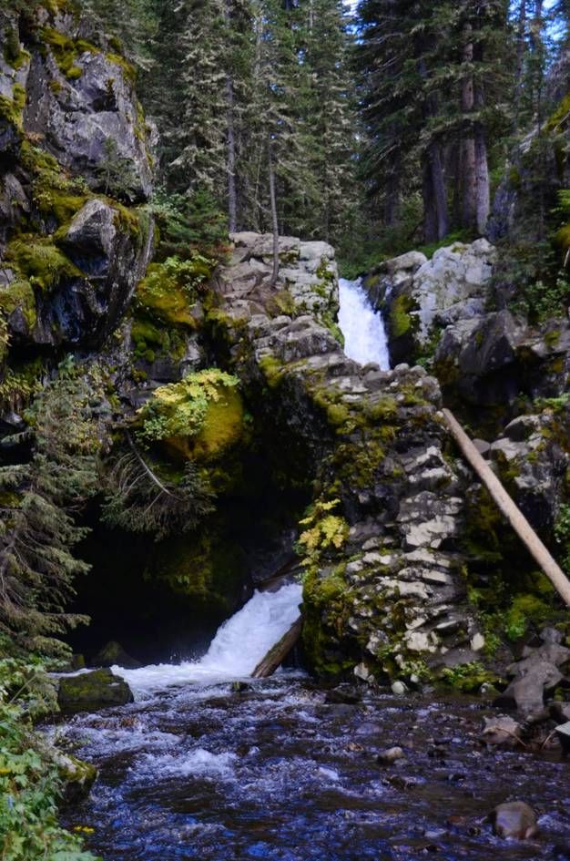 Tiered waterfall through moss-covered rocks in rocky canyon