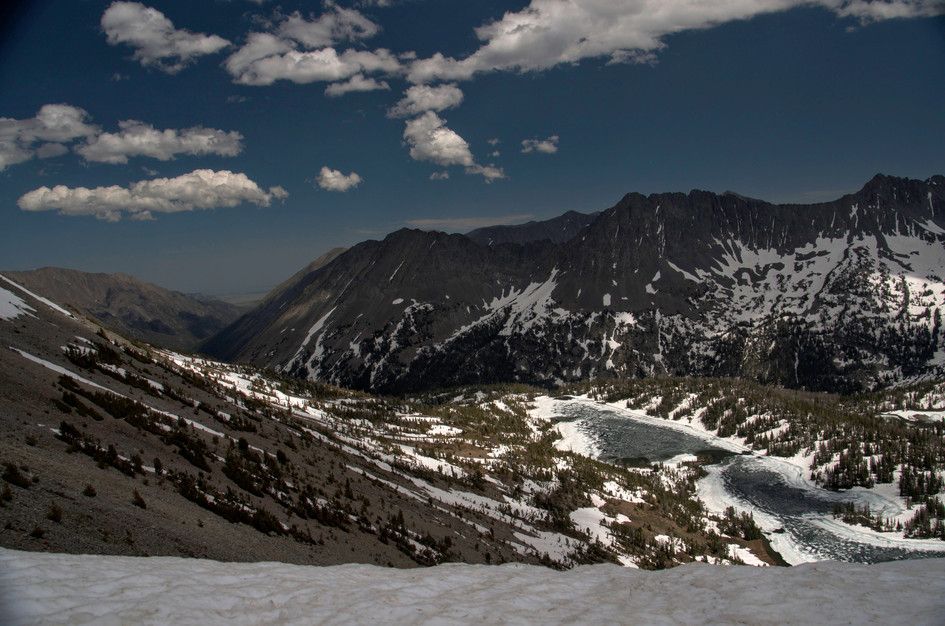 Panoramic ridge view of frozen Campfire Lake surrounded by snow-covered peaks