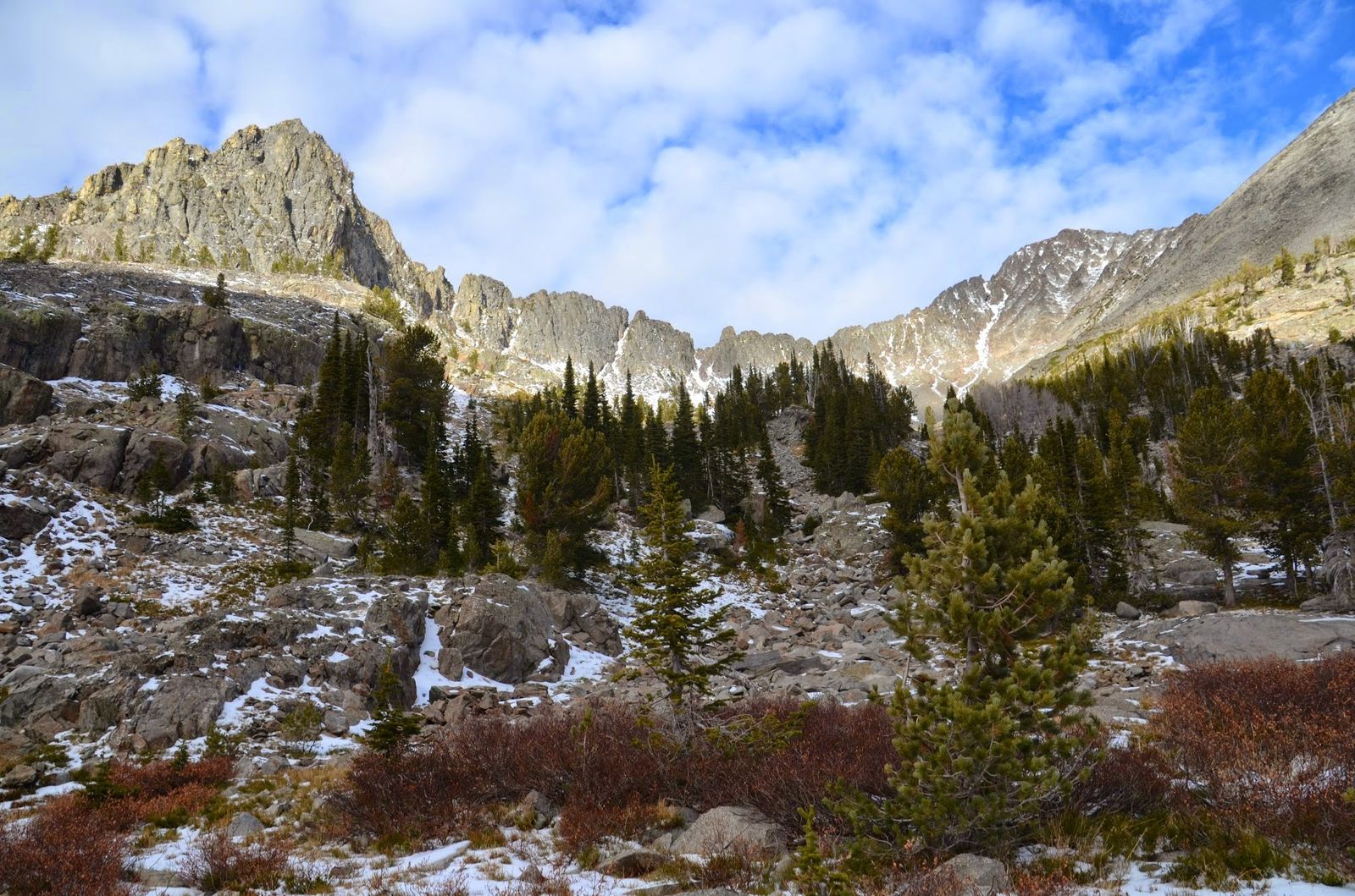 Dramatic granite spires and peaks surrounding alpine basin with scattered pines