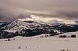 Snow-covered Lamar Valley under a dramatic winter sky with rolling forested hills
