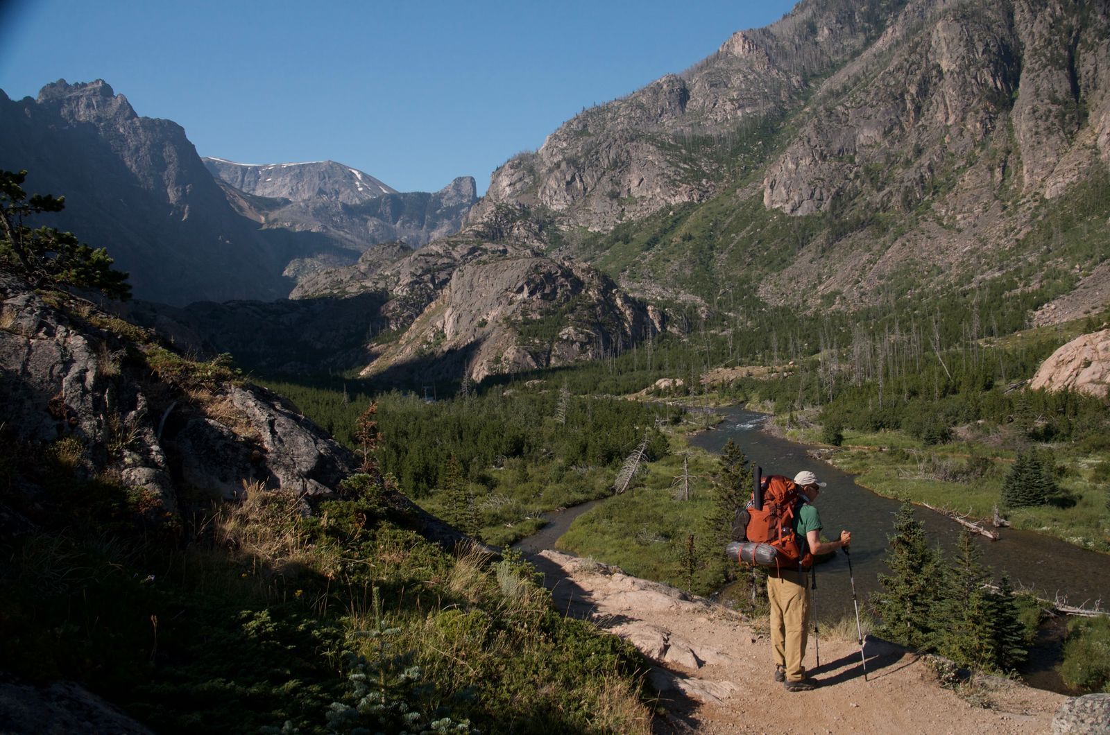 Backpacker overlooking East Rosebud Creek valley with towering granite walls