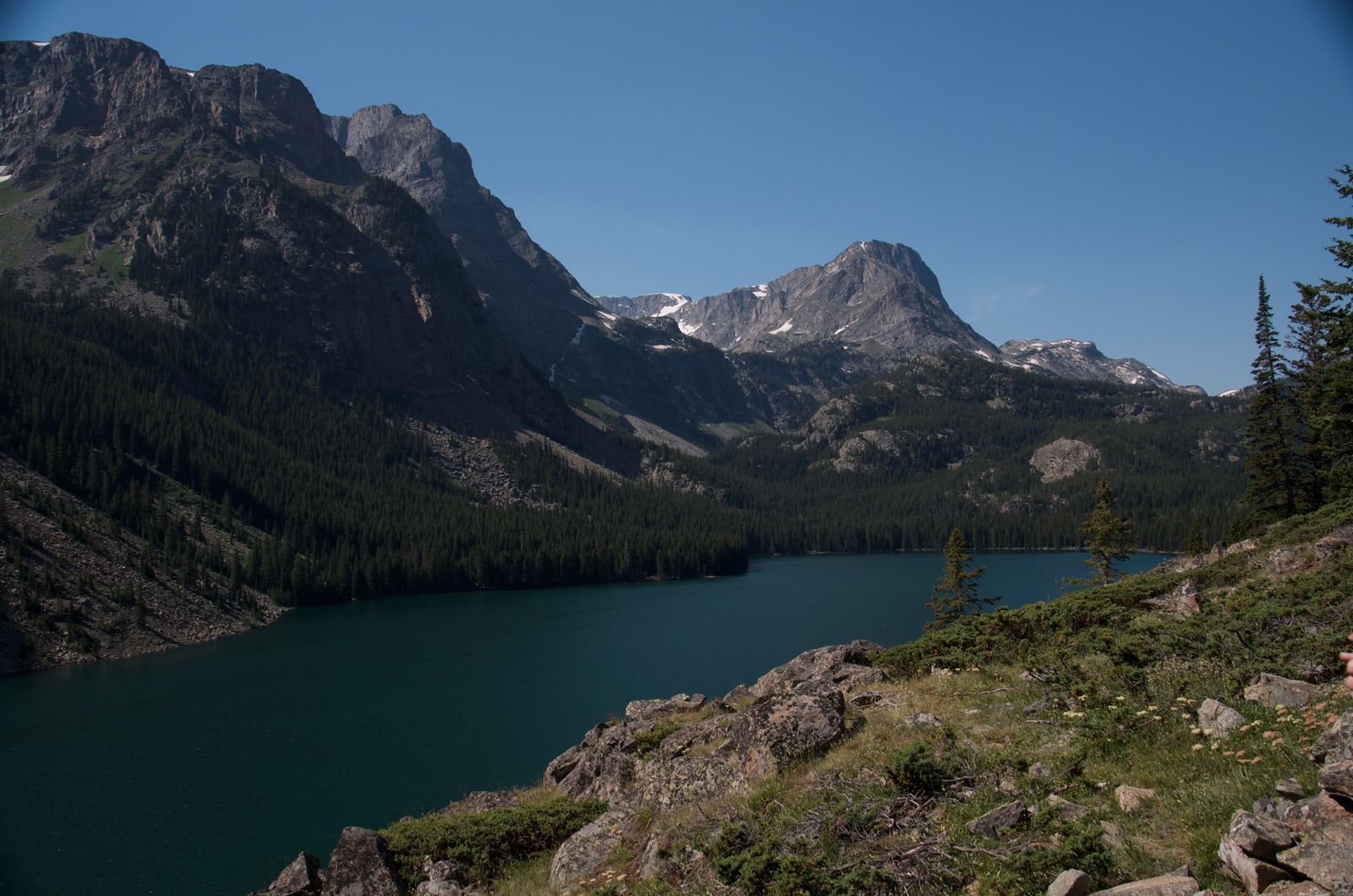 Alpine lake surrounded by dramatic Beartooth granite peaks and evergreen forest