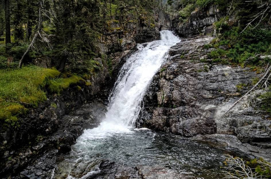 Big Timber Falls cascading down rocky cliff into pool surrounded by forest