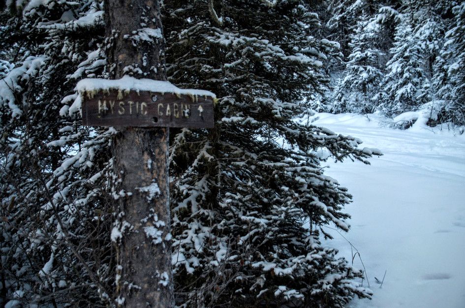 Snowy sign pointing toward Mystic Cabin on the winter route