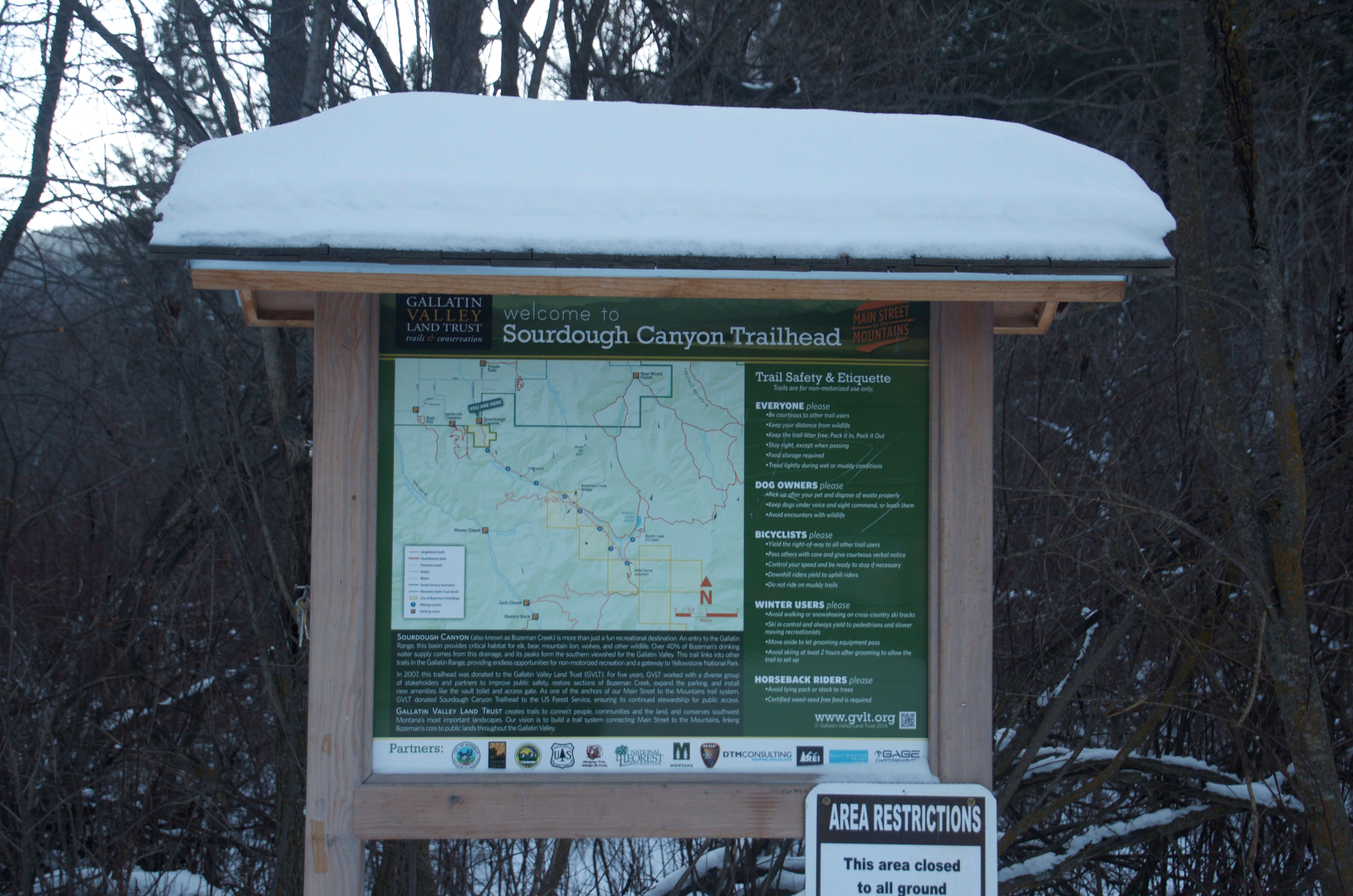 Snow-covered Sourdough Canyon Trailhead information kiosk