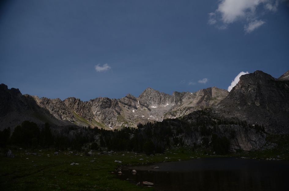 Dramatic view of granite peaks and alpine lake in deep afternoon shadow