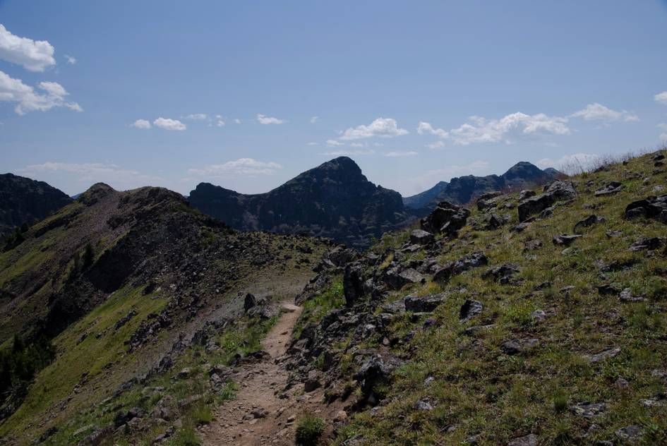 Rocky ridgeline trail with dramatic Hyalite peaks in background