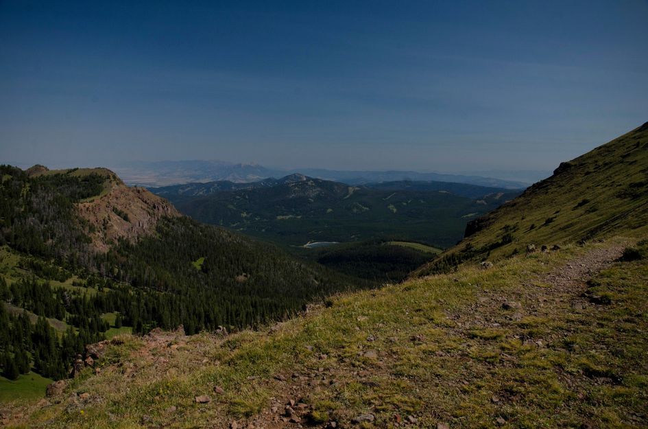 View down alpine basin toward Hyalite Reservoir and distant mountains