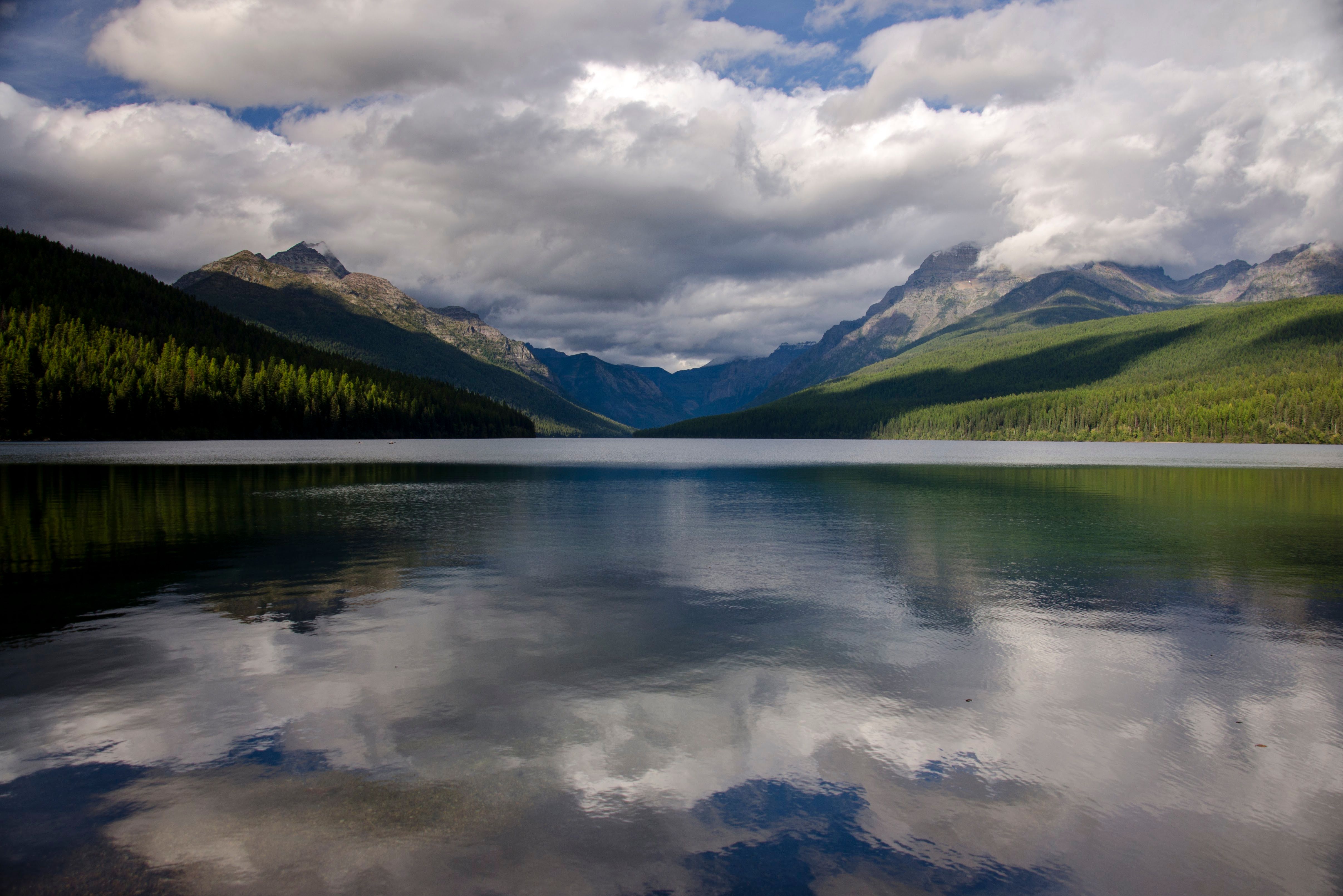 Bowman Lake reflecting dramatic clouds and forested mountains