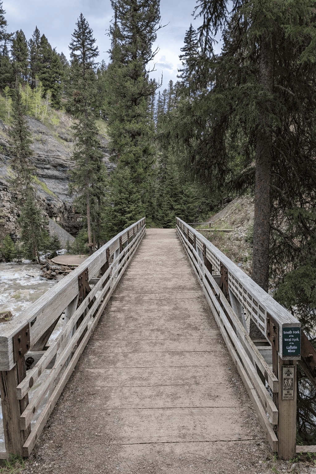 Wooden footbridge with handrails crossing the Gallatin River tributary
