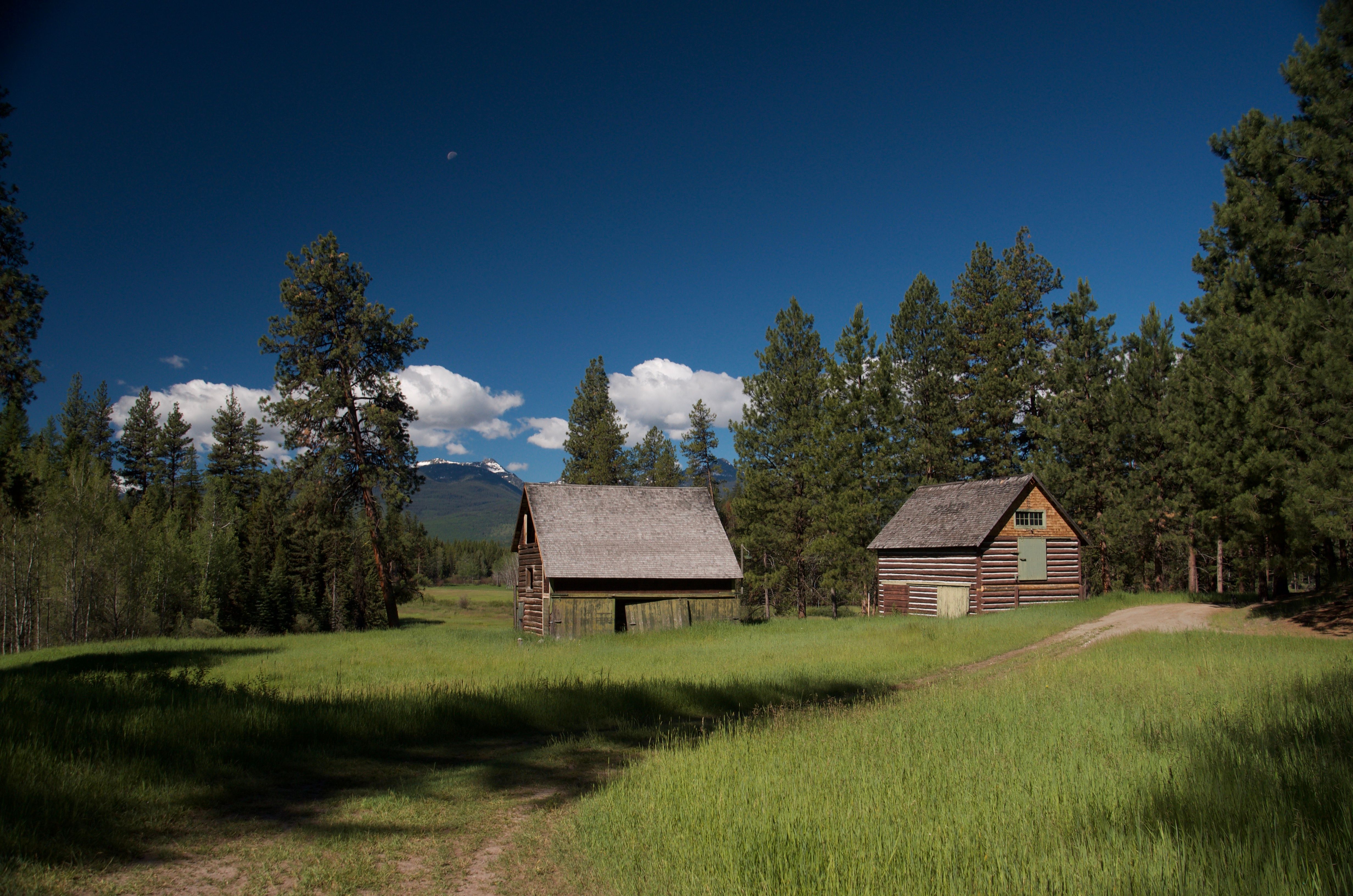 The original 1920s barn and outbuildings on the Condon Ranger Station property with snow-capped mountains in the background