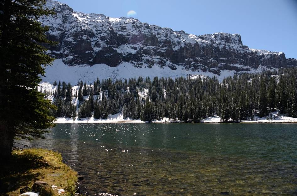 Emerald Lake with clear green water reflecting massive rock cliffs