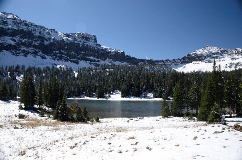 Wide view of Emerald Lake basin with snow-covered mountains on both sides