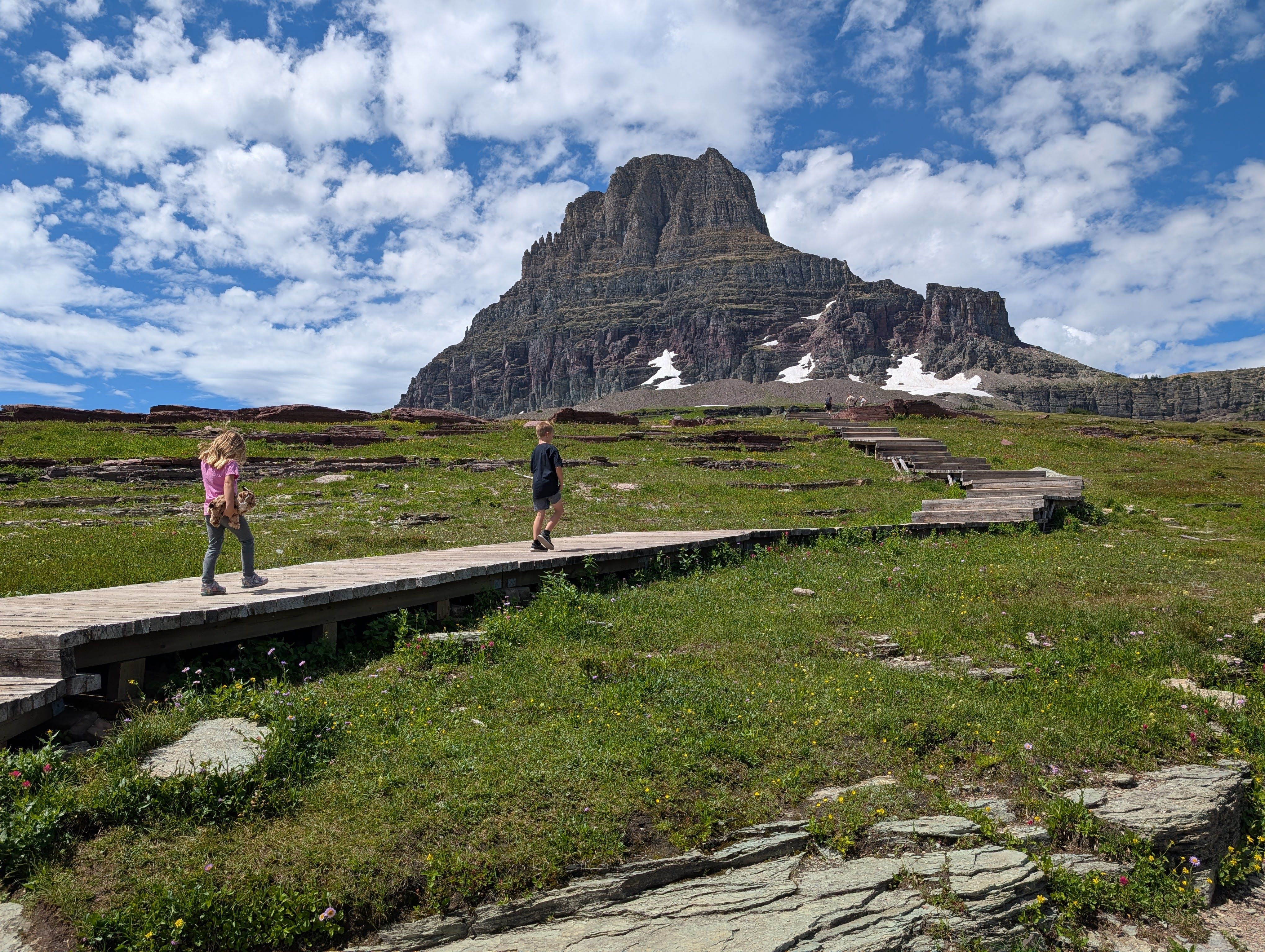 Kids walking on boardwalk with Clements Mountain towering behind on sunny day