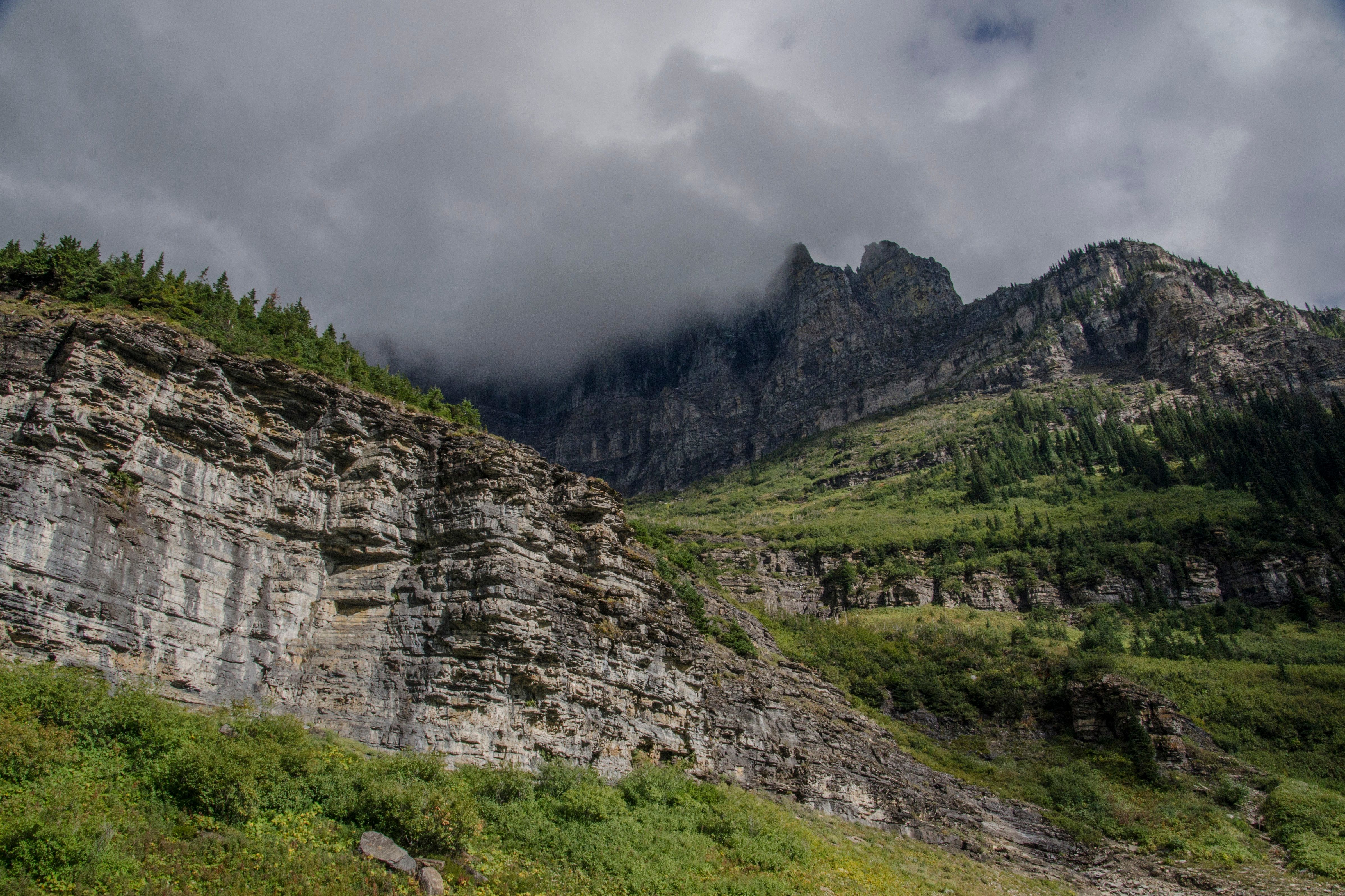 Cliff face along Going-to-the-Sun Road with clouds hugging the peaks
