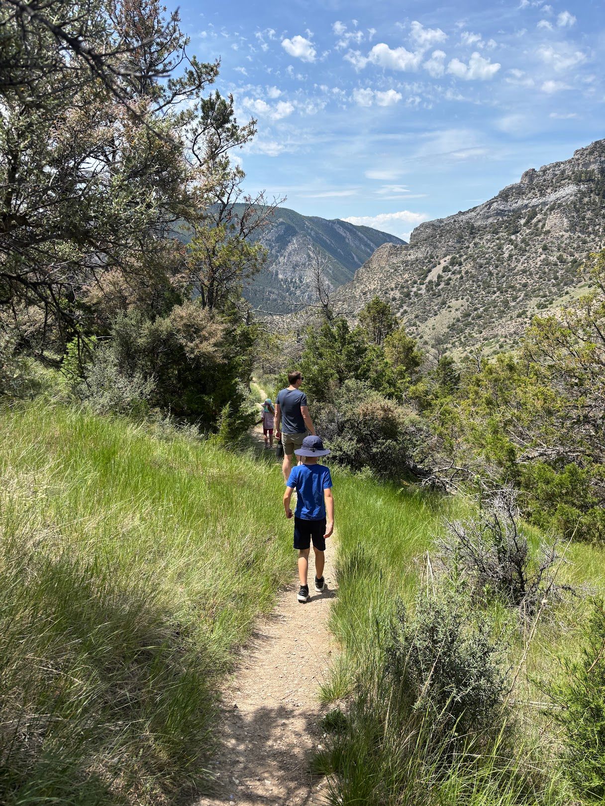 Father and child hiking the trail with mountain views