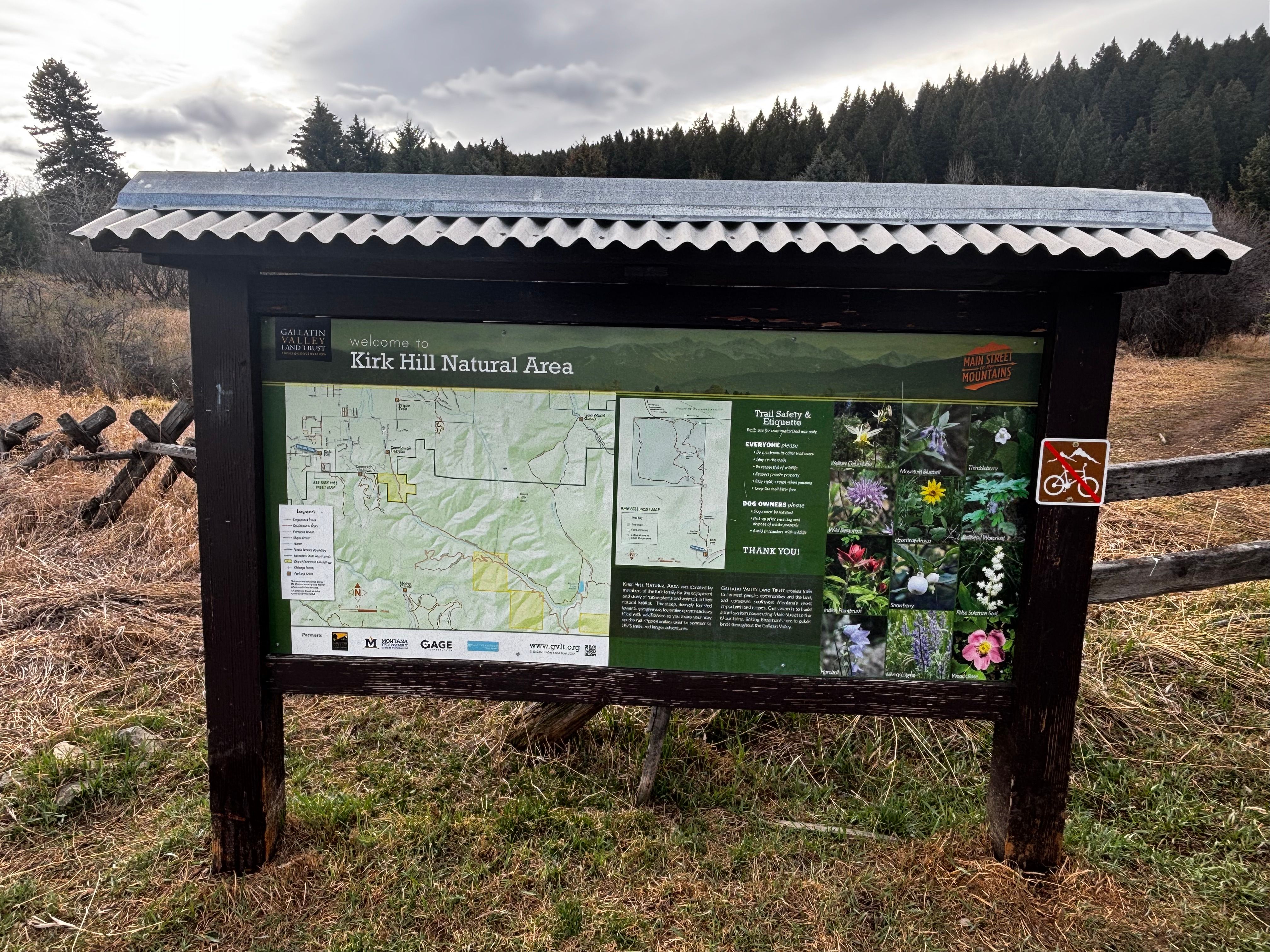 Kirk Hill Natural Area kiosk showing trail map and wildflower identification photos