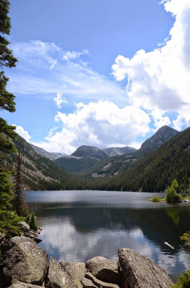 Lava Lake framed by pine trees with dramatic mountain backdrop