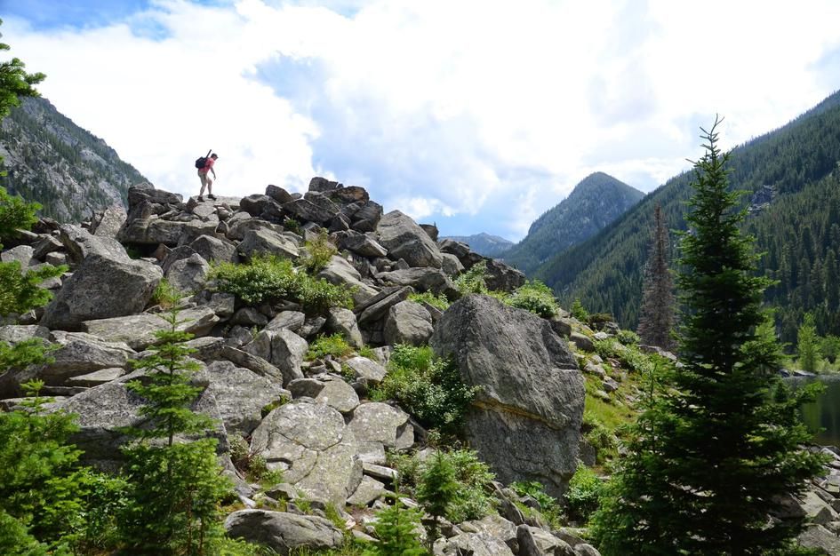 Hiker exploring boulder field with Spanish Peaks mountain backdrop