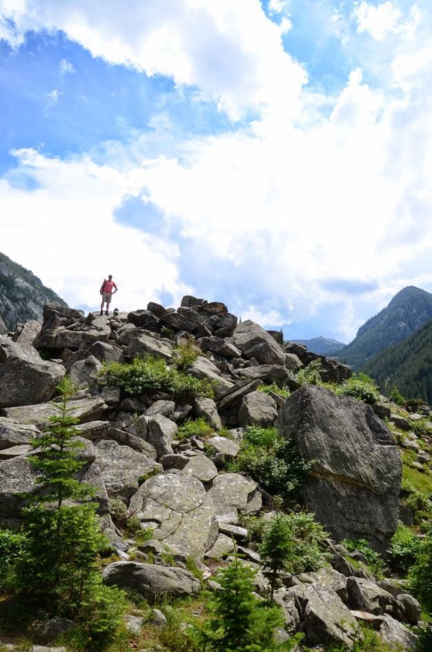 Hiker standing atop boulder pile with mountain valley views