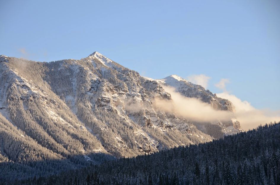 Snow-covered mountain peaks with low clouds in Hyalite Canyon