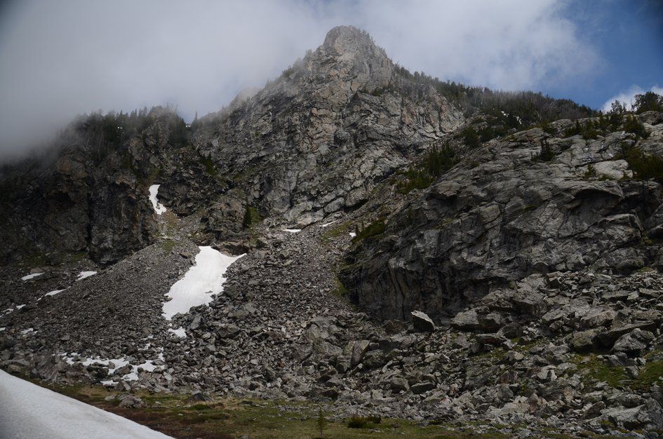 Rugged granite peak with steep talus slopes and lingering snow patches