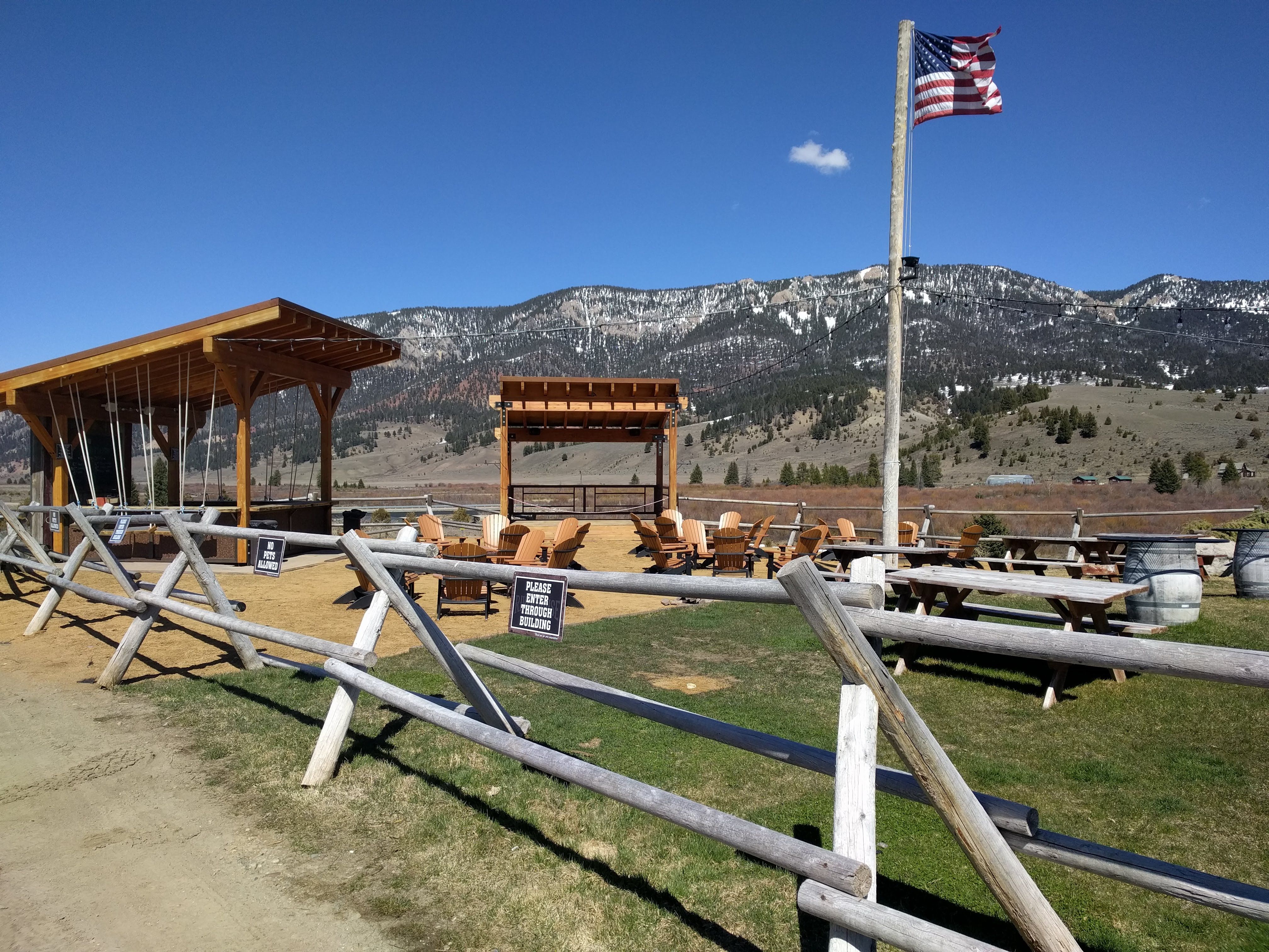 Riverhouse BBQ outdoor patio with Adirondack chairs, American flag, and mountain views