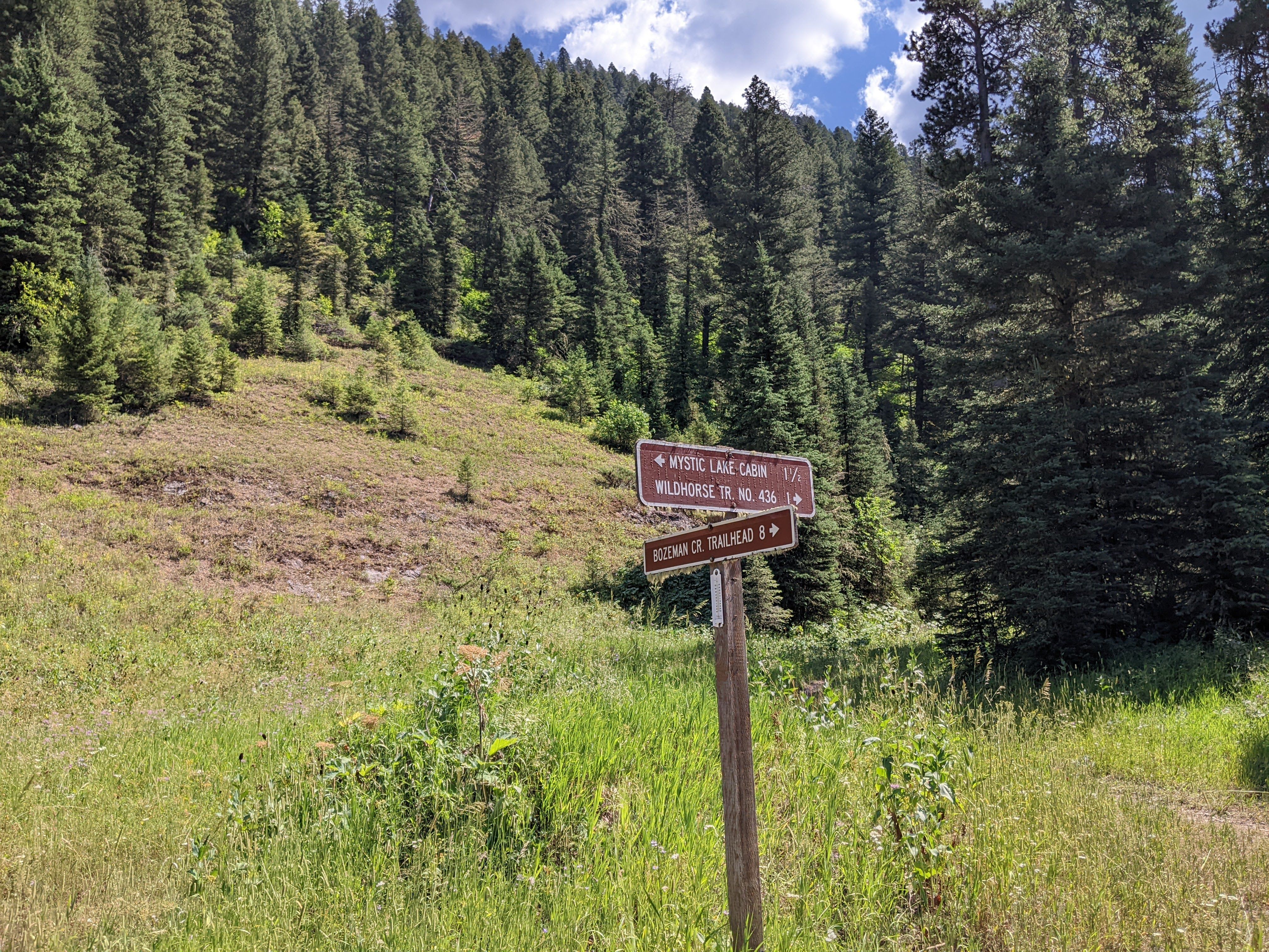 Trail sign pointing toward Mystic Lake Cabin and Bozeman Creek Trailhead
