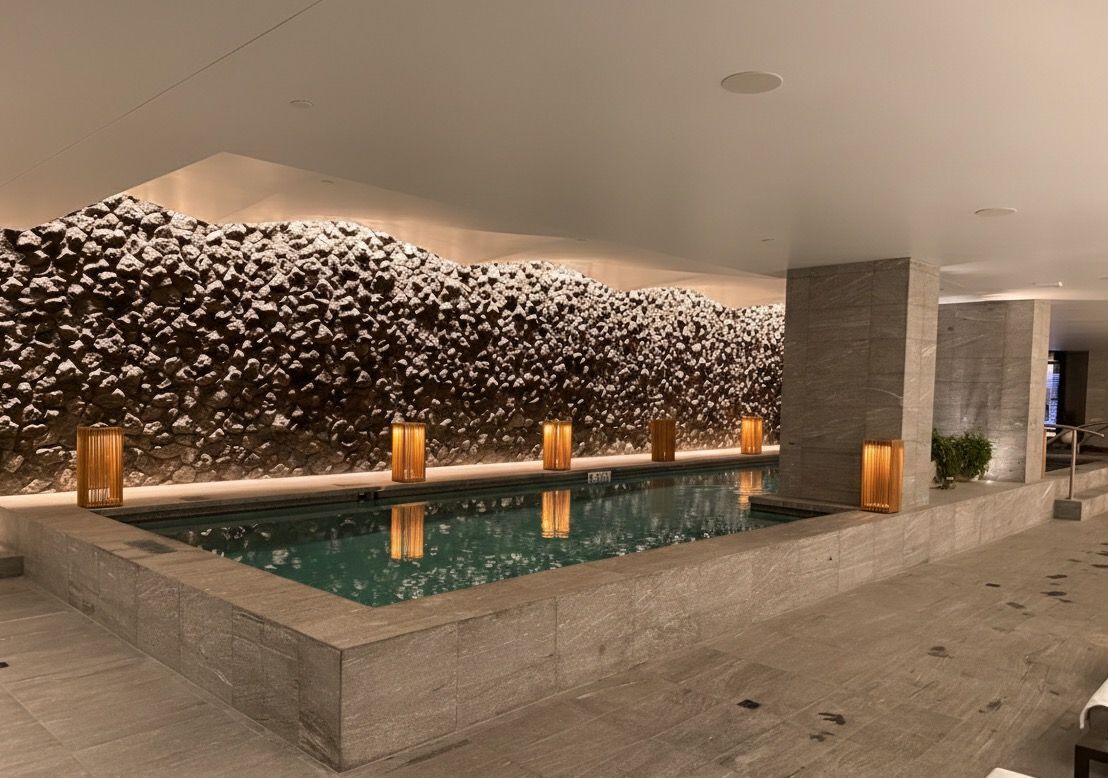 Luxury spa pool with natural stone wall feature and warm ambient lighting