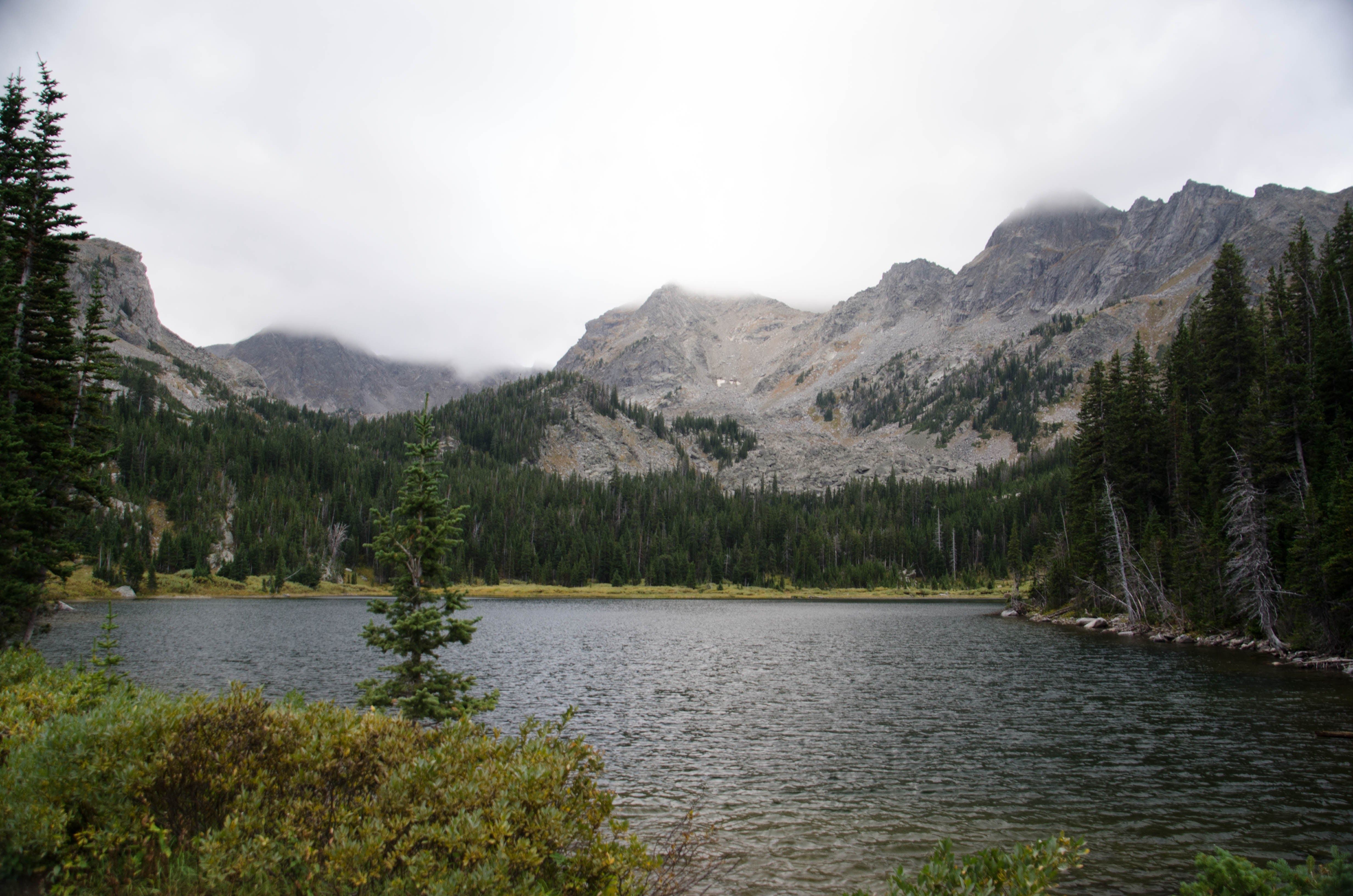 Mirror Lake with cloud-wrapped peaks and evergreen forest