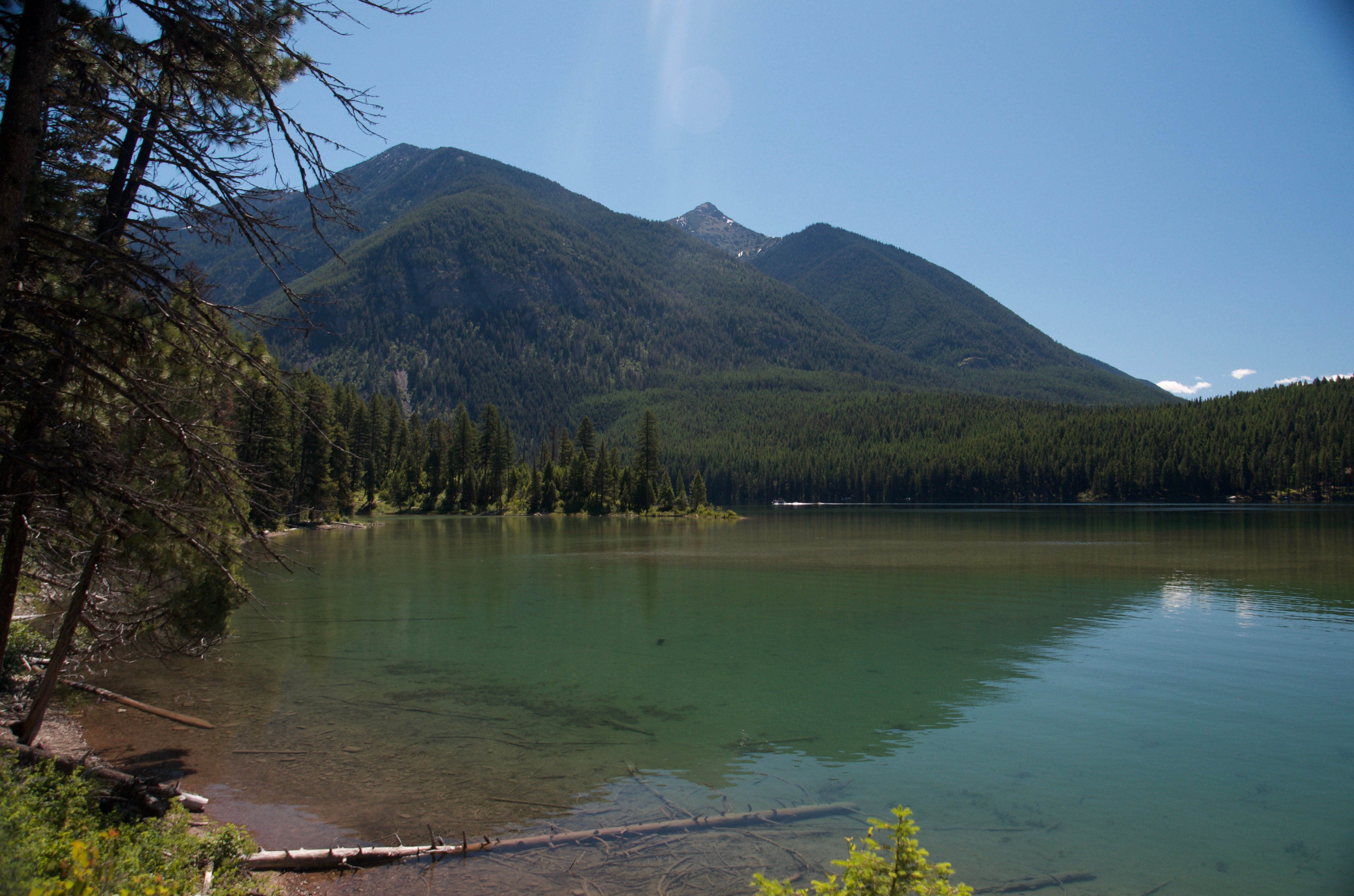 Holland Lake with a steep forested mountain rising directly behind it