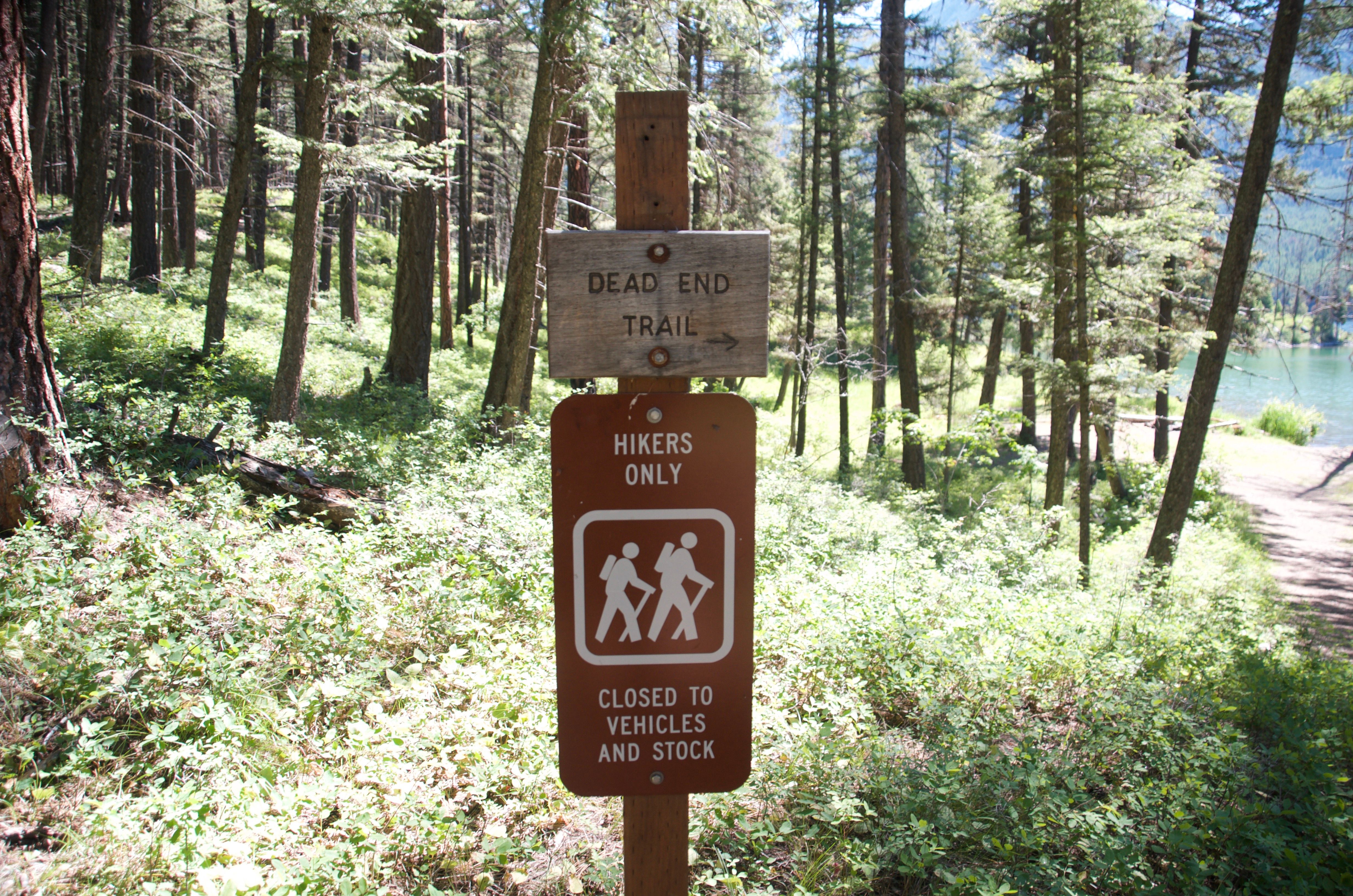 Dead End Trail and Hikers Only sign at the Holland Falls trailhead with the lake visible behind