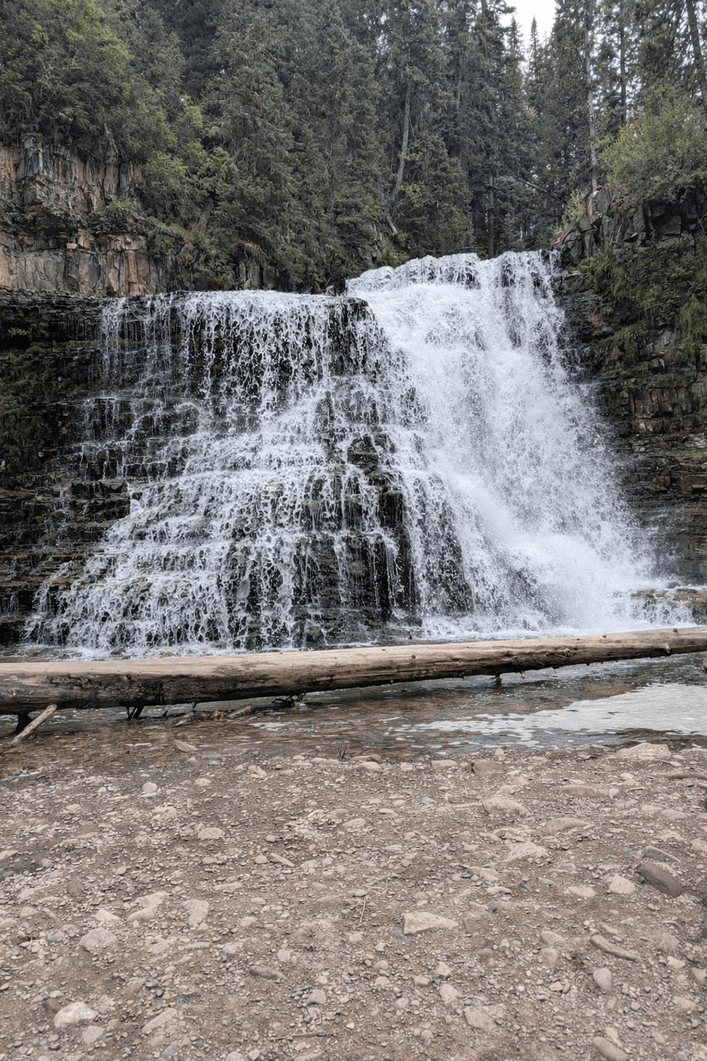 Ousel Falls front view showing cascading tiers with driftwood log