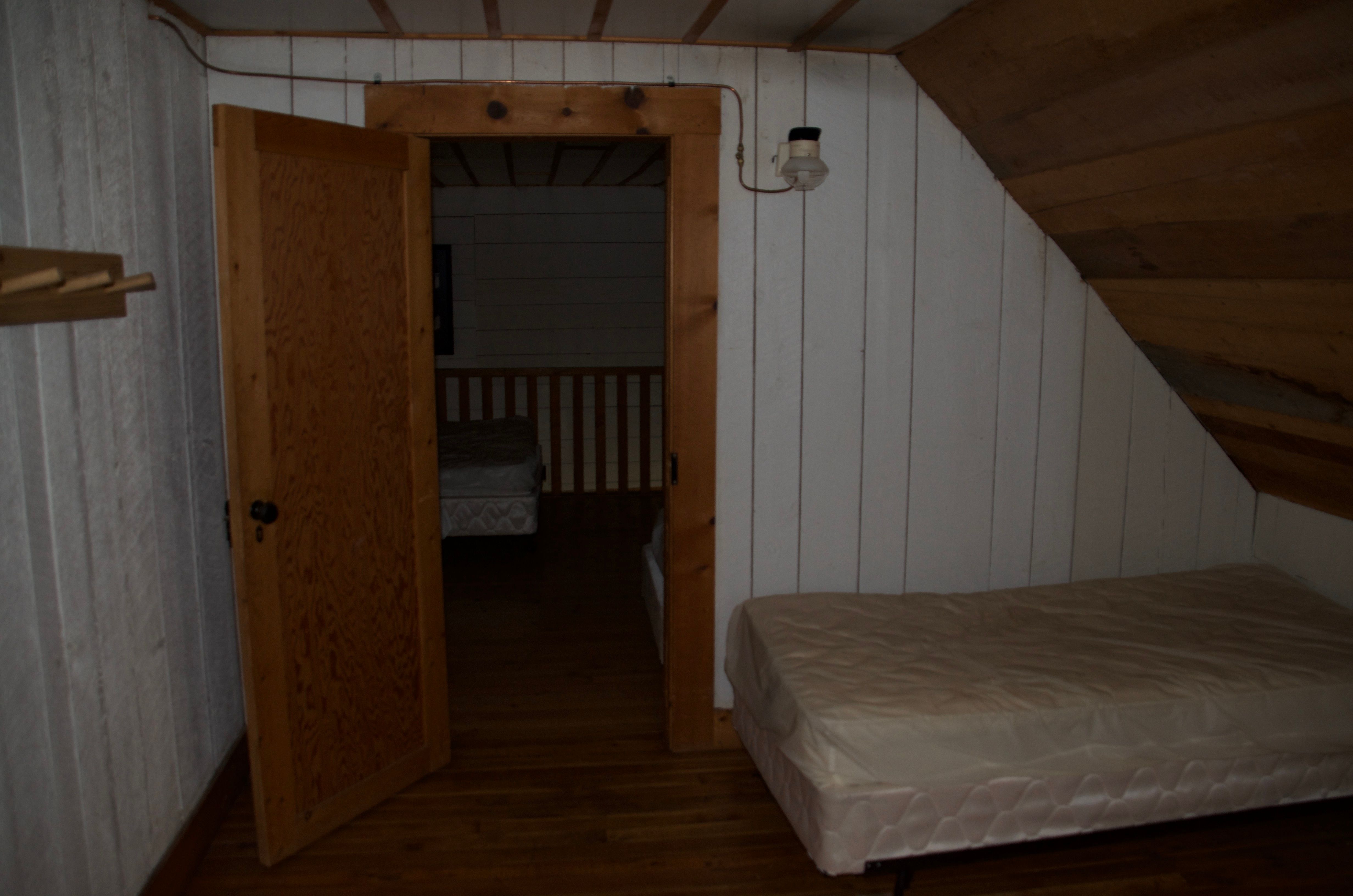 Doorway between two loft bedrooms at Wurtz Cabin with twin beds visible in both rooms