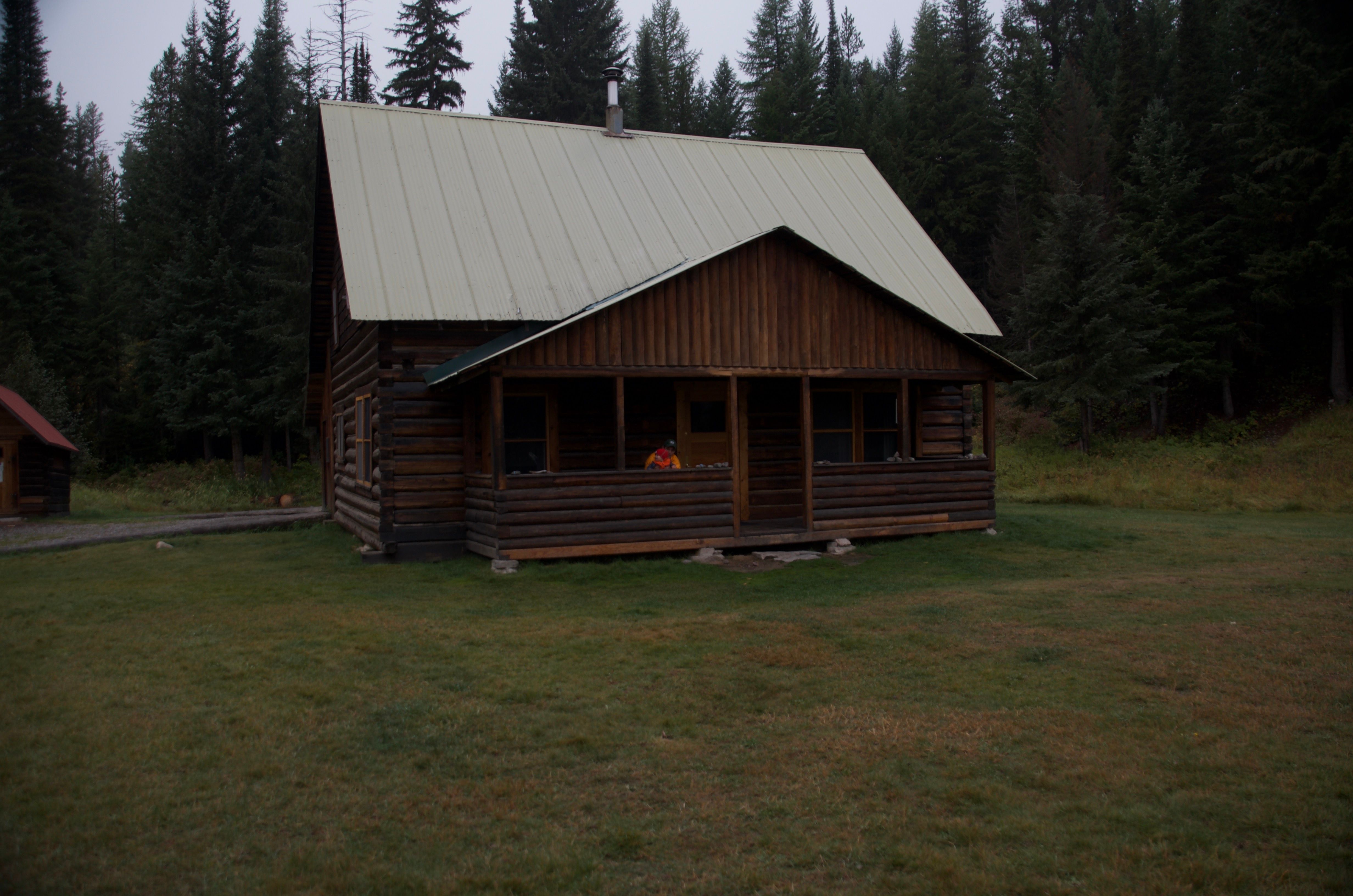 Wurtz Cabin at dusk with a person on the covered front porch