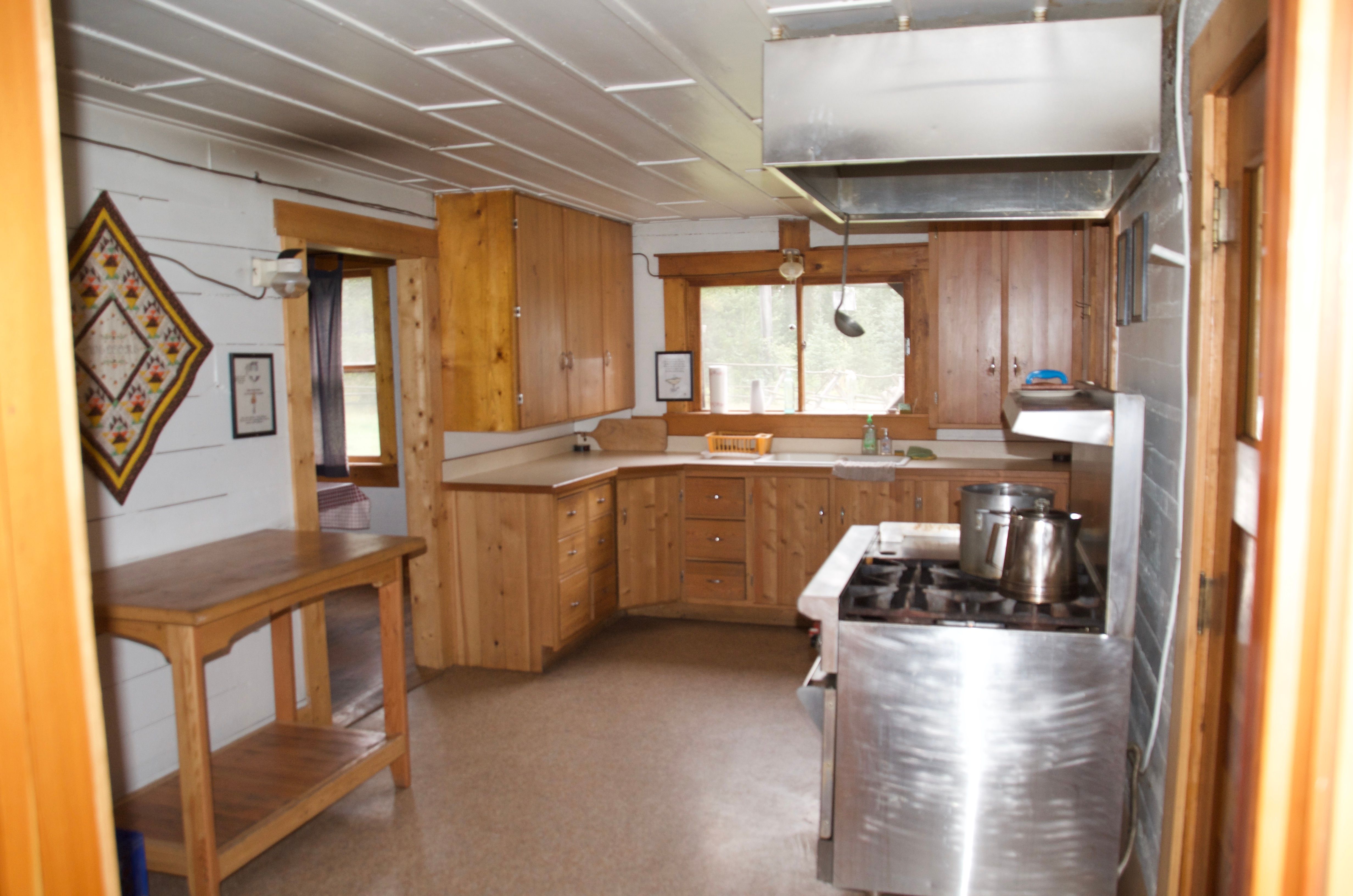 The Wurtz Cabin kitchen with its Wolf commercial range, wood cabinetry, prep island, and ample counter space