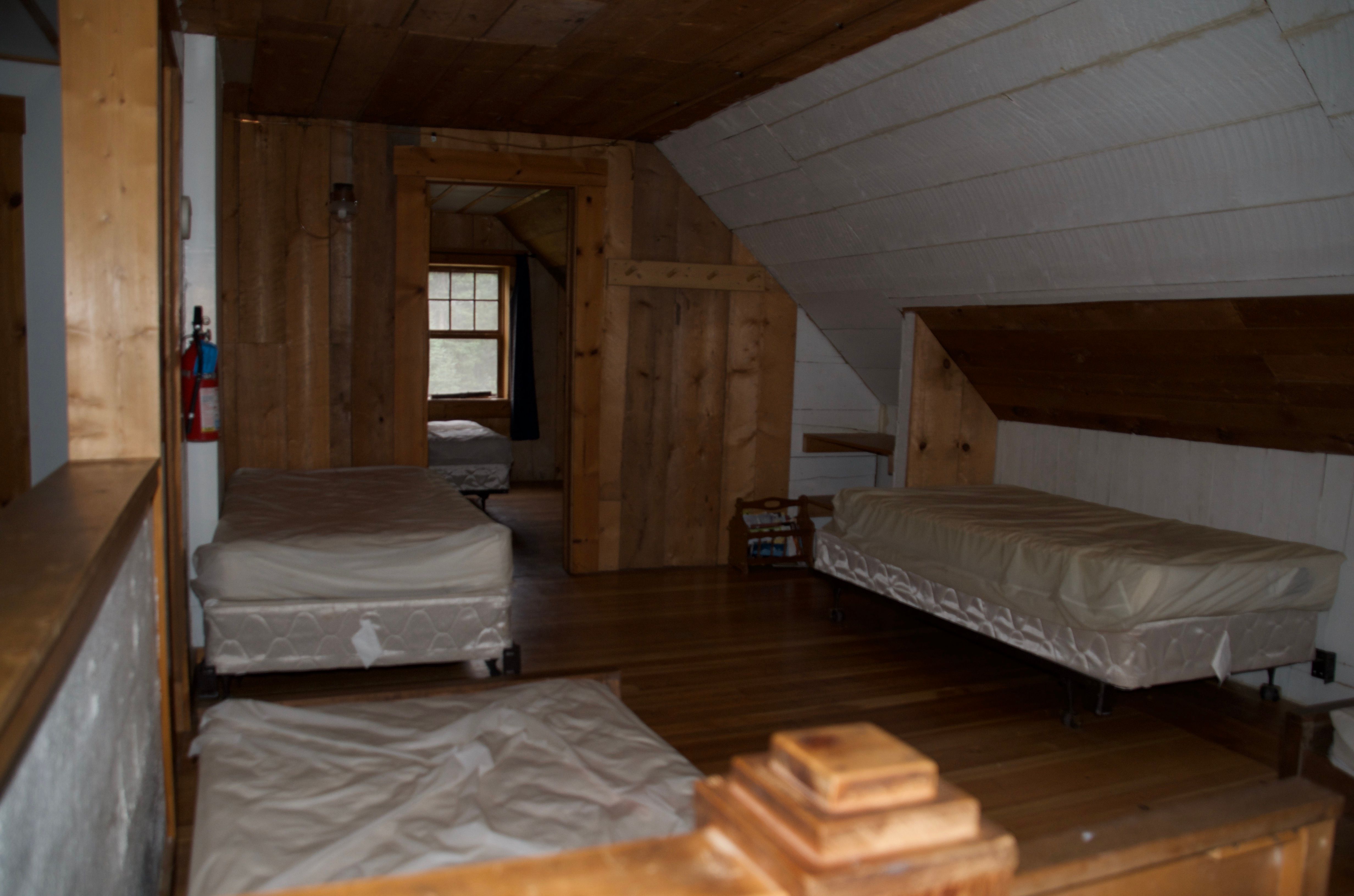 The upstairs sleeping loft at Wurtz Cabin with multiple twin beds in an open layout
