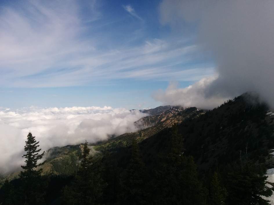 Bridger Ridge with clouds swirling around rocky peaks and scattered pines