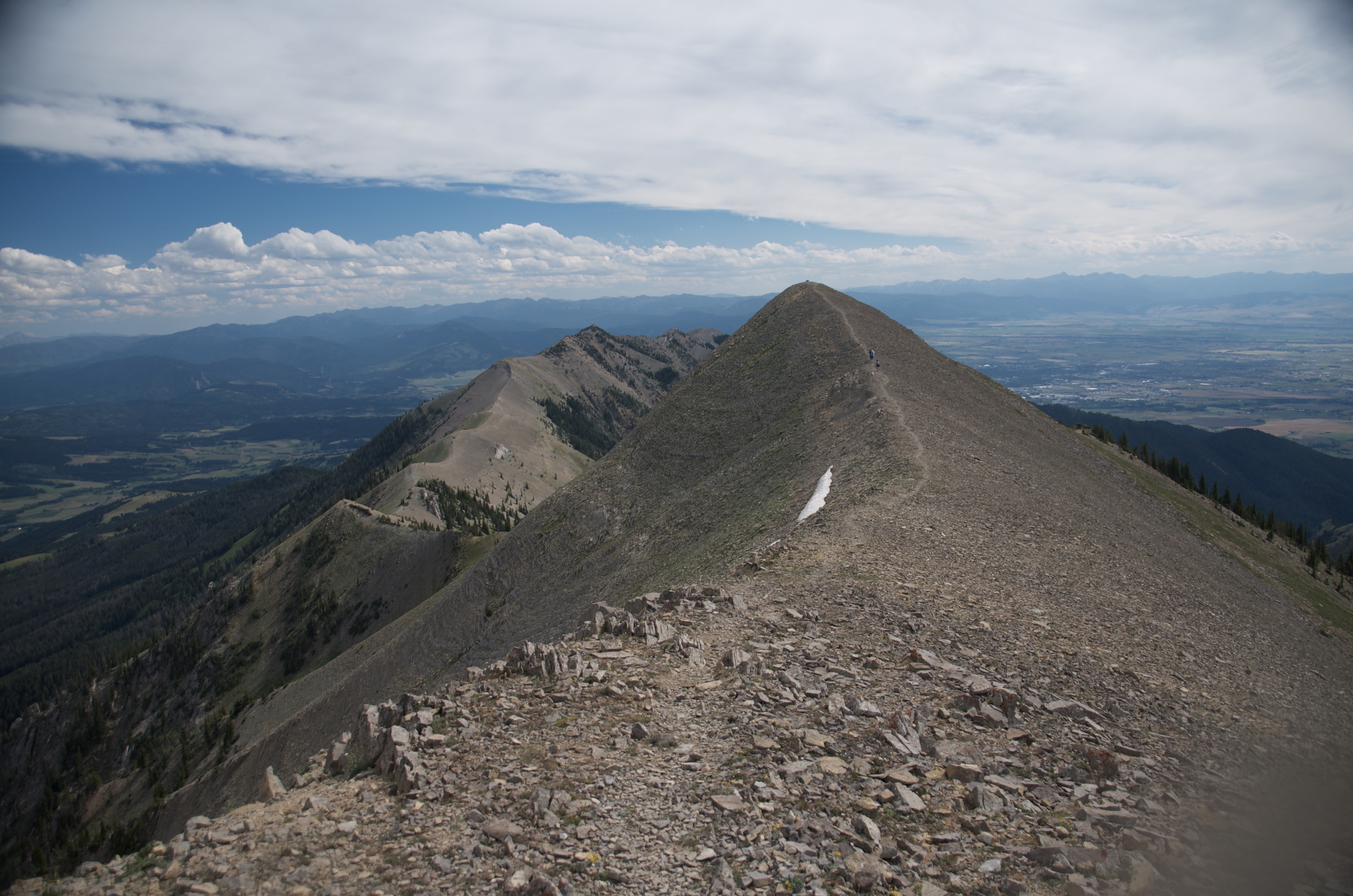 Looking along narrow rocky Bridger Ridge spine toward multiple peaks ahead with valley visible on both sides