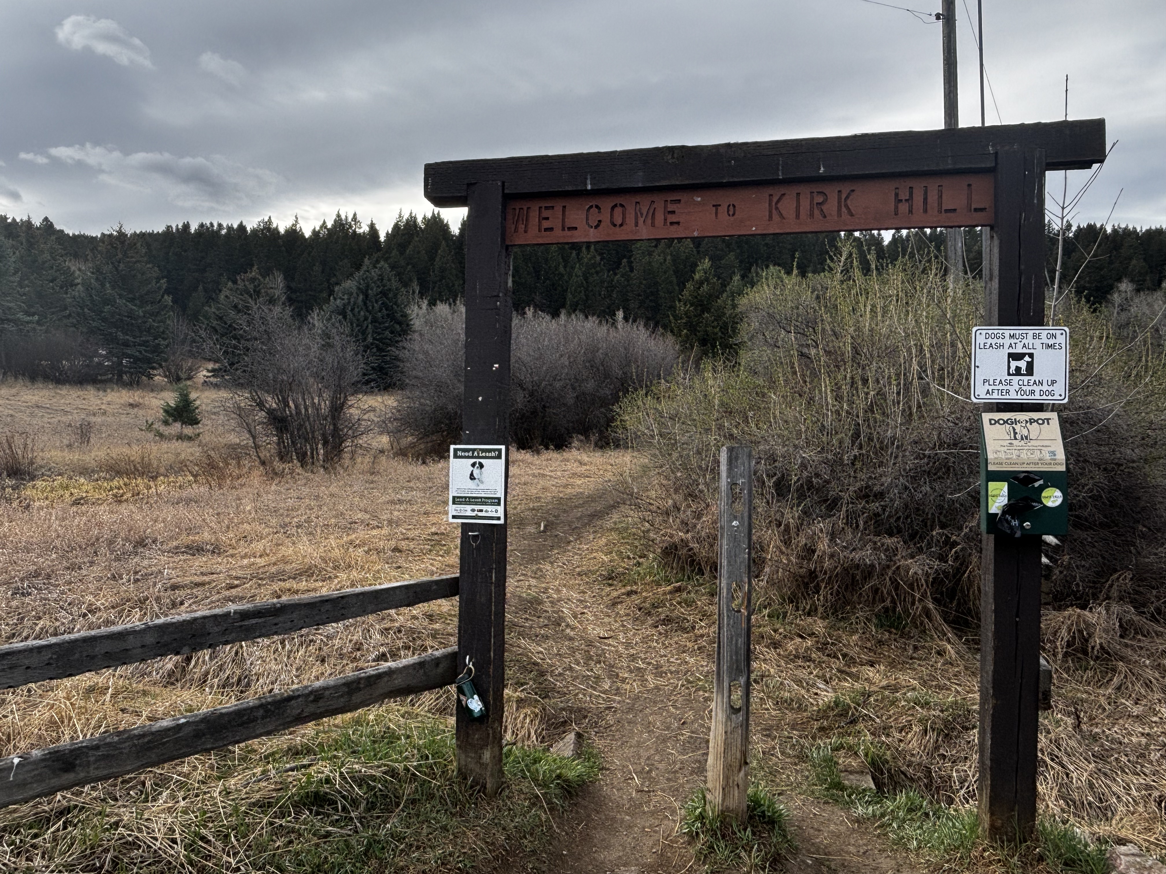 Welcome to Kirk Hill entrance gate with dog leash required signs posted at the trailhead