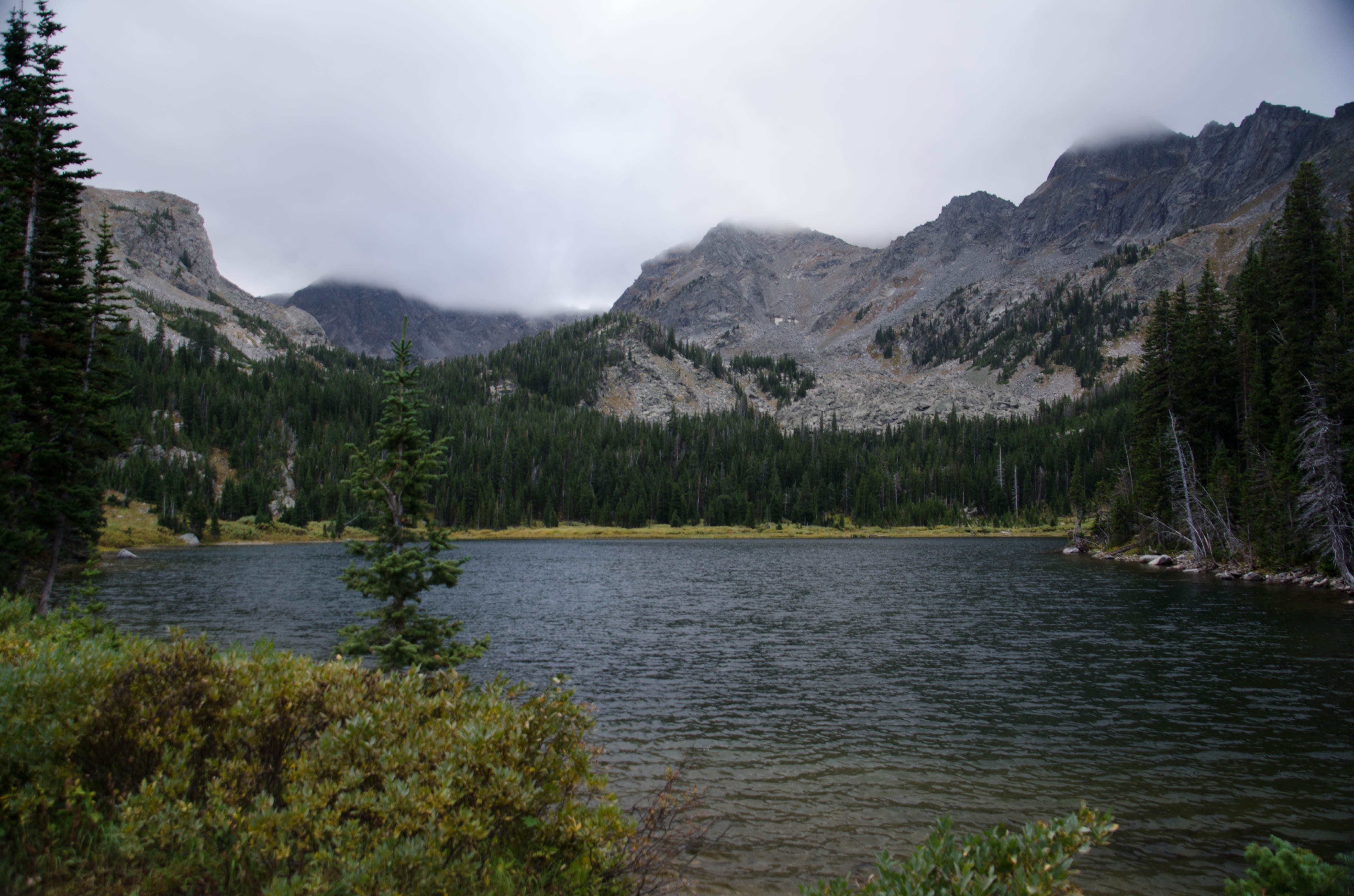 Mirror Lake with rocky Spanish Peaks rising behind under cloudy skies