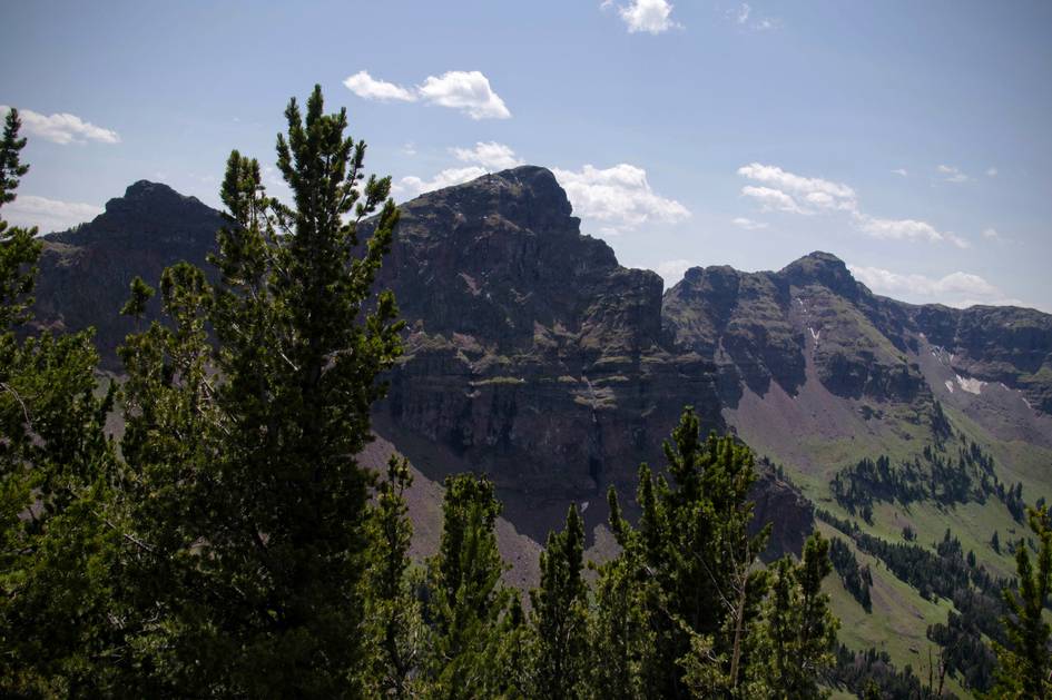 Dramatic rock cliffs and peaks framed by subalpine fir trees