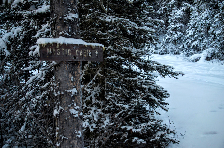 Snowy sign pointing toward Mystic Cabin on the winter route