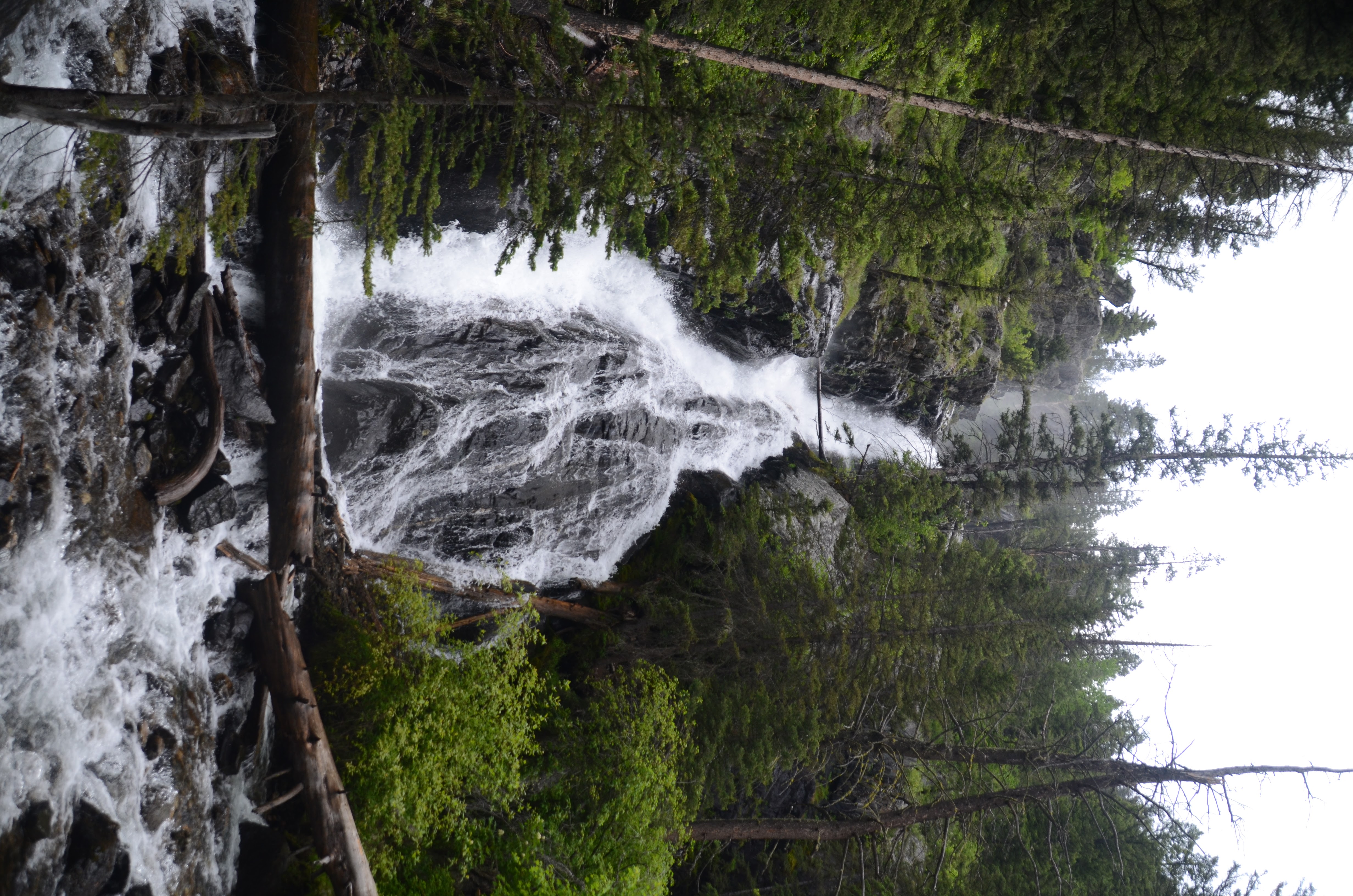 Pine Creek Falls viewed from a distance through the trees