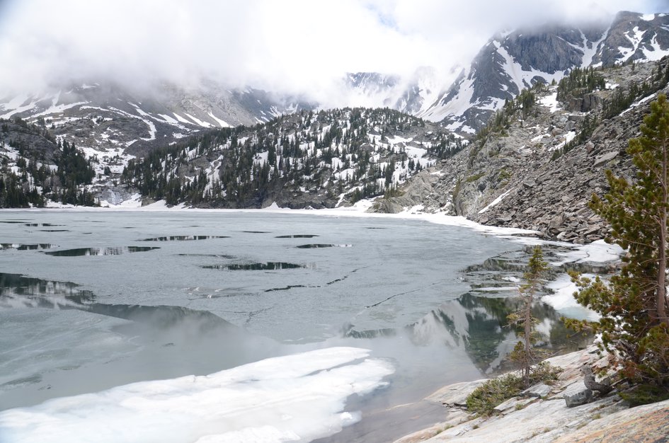 Upper Pine Creek Lake still partially frozen with ice floes and rocky cirque