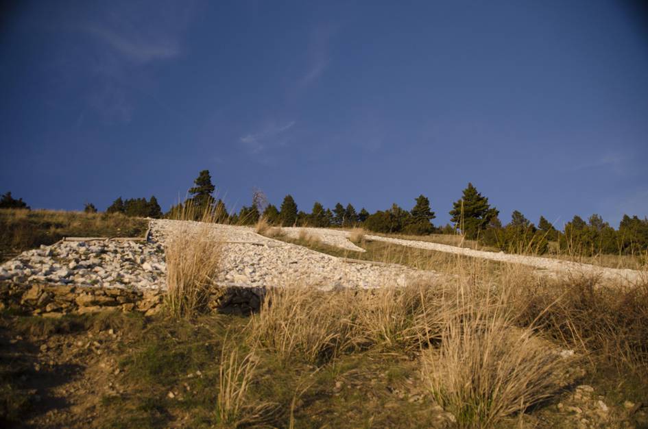 The M formed by white limestone rocks on grassy hillside