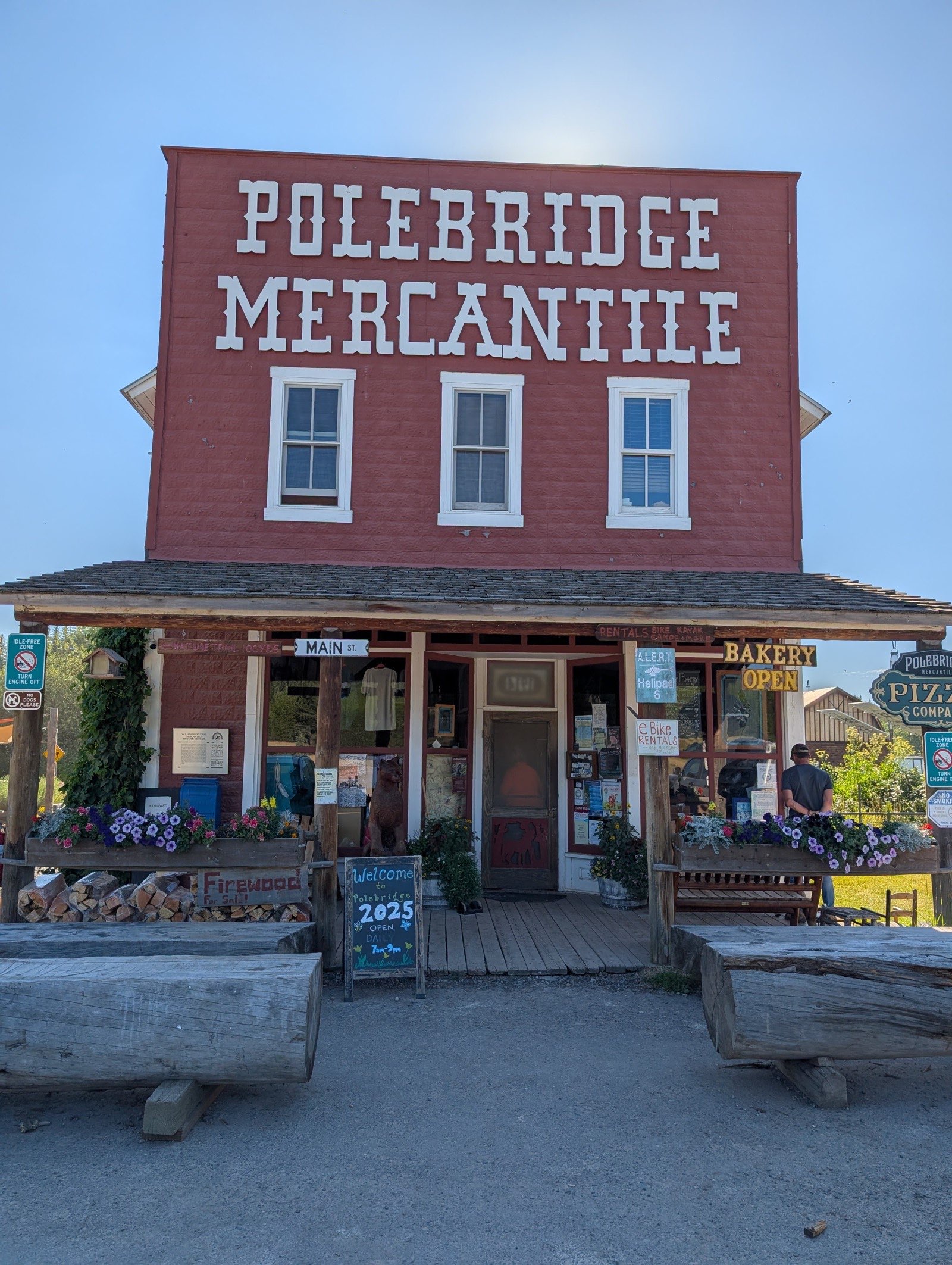 Historic Polebridge Mercantile building with red facade, wooden porch, and Bakery Open sign